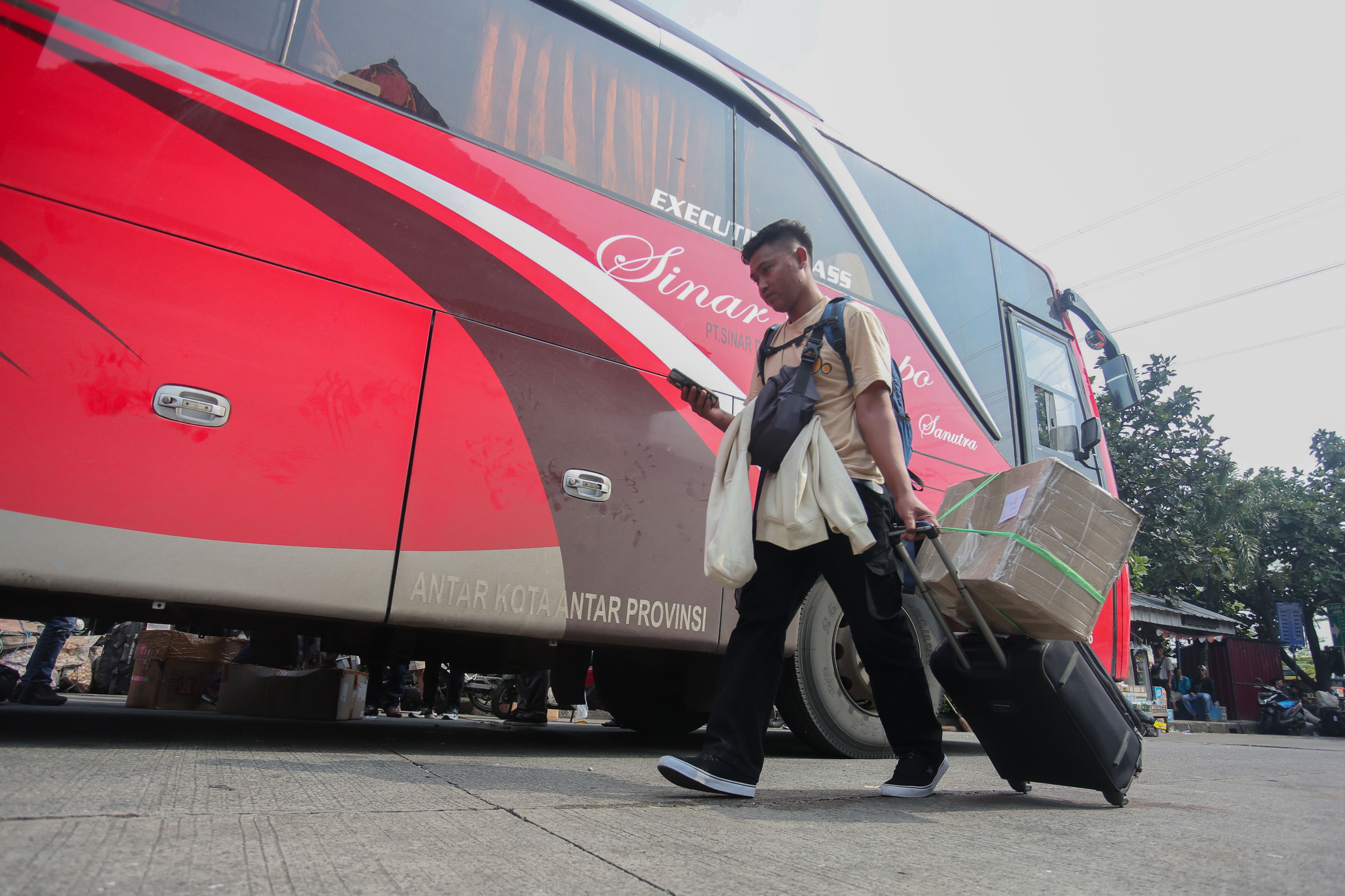 Seorang pemudik membawa barang bawaan saat akan memasuki bus di Terminal Kampung Rambutan, Jakarta, Minggu (7/4/2024). Berdasarkan data Kepala Terminal Kampung Rambutan Yulza Ramadhoni, pada H-3 Lebaran telah diberangkatkan 168 bus dengan jumlah penumpang sebanyak 3.111.