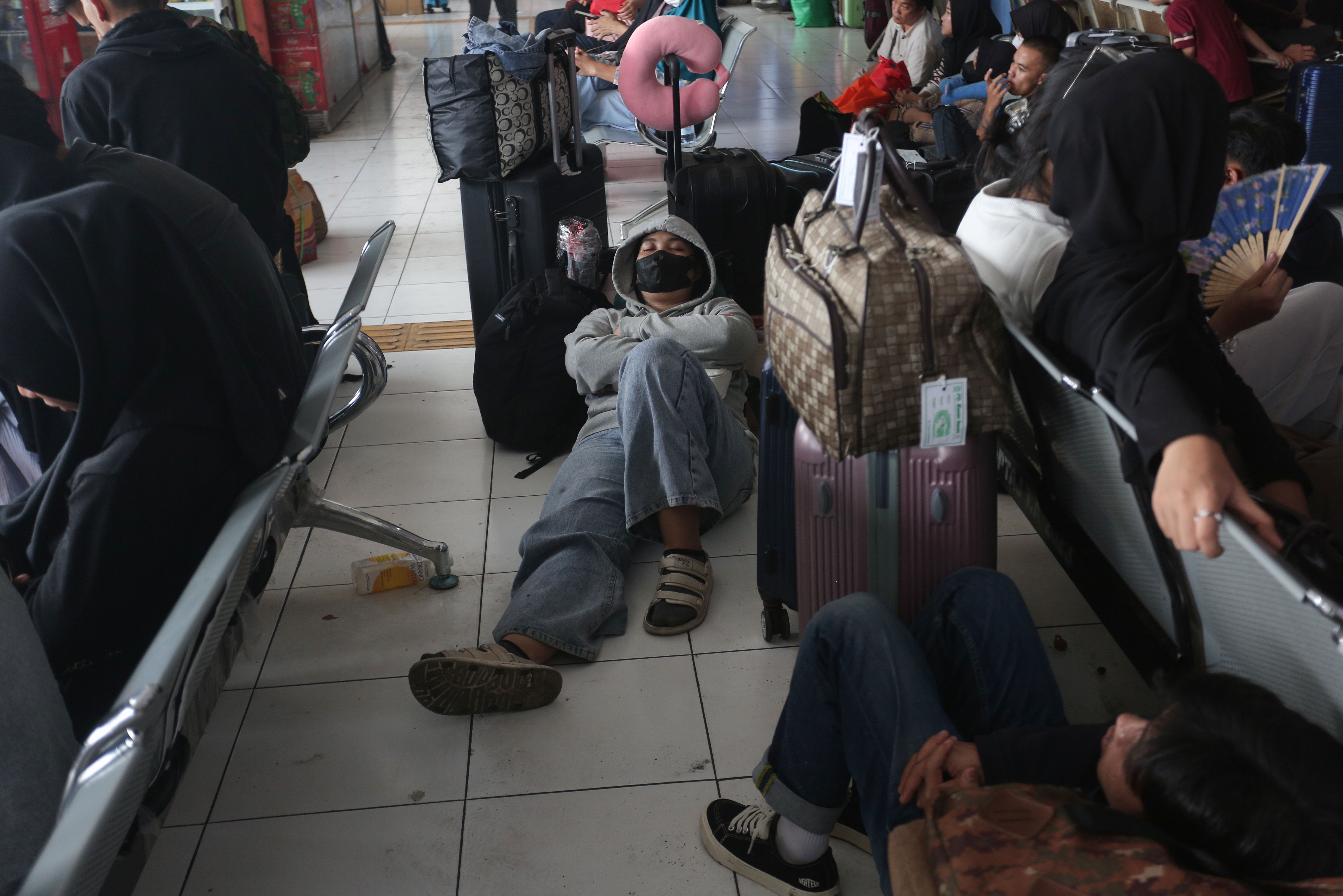 Seorang pemudik tertidur ketika menunggu keberangkatan bus di Terminal Kampung Rambutan, Jakarta, Minggu (7/4/2024). Berdasarkan data Kepala Terminal Kampung Rambutan Yulza Ramadhoni, pada H-3 Lebaran telah diberangkatkan 168 bus dengan jumlah penumpang sebanyak 3.111.