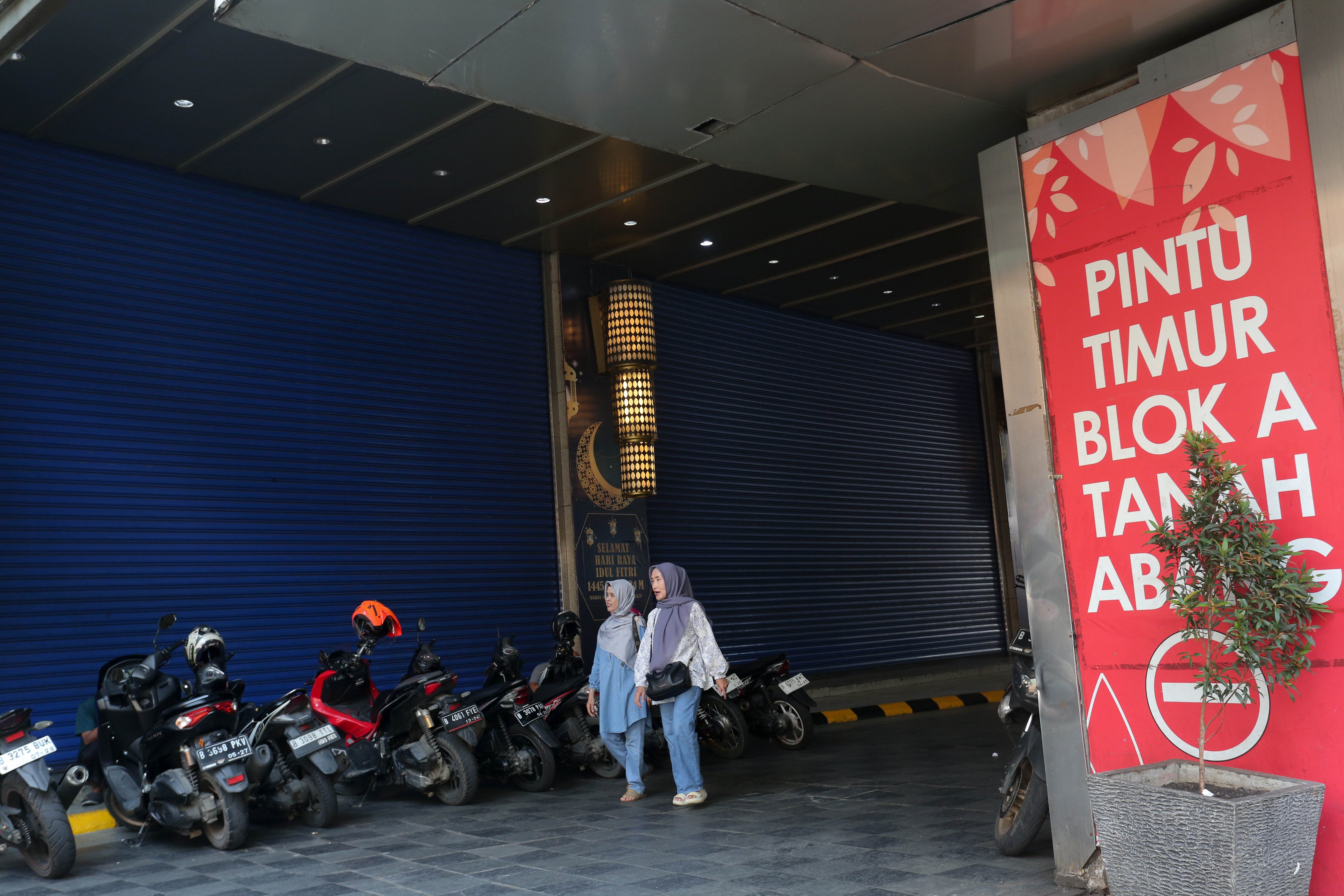 Dua orang warga berjalan di sekitar area Pasar Blok A Tanah Abang saat tutup di Jakarta, Rabu (17/4/2024). Dalam rangka perawatan gedung dan peralatan pendukung operasional, pengelola Pasar Blok A Tanah Abang menutup kawasan perbelanjaan tersebut dari 10 hingga 21 April 2024.