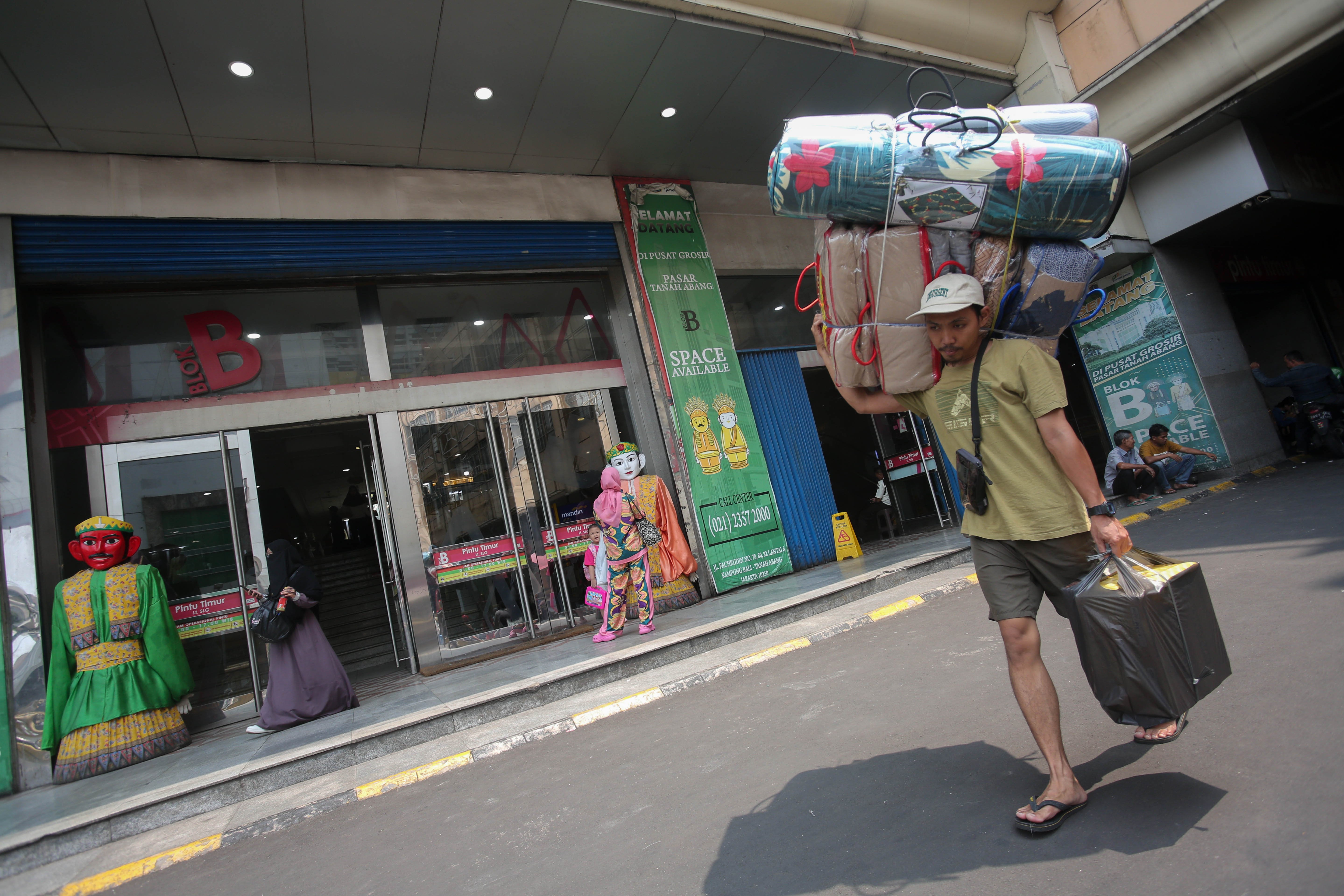 Seorang warga membawa barang setelah berbelanja di Pasar Blok B Tanah Abang, Jakarta, Rabu (17/4/2024). Pasar Blok B Tanah Abang kembali dibuka setelah sebelumnya ditutup pada 10 hingga 16 April 2024.