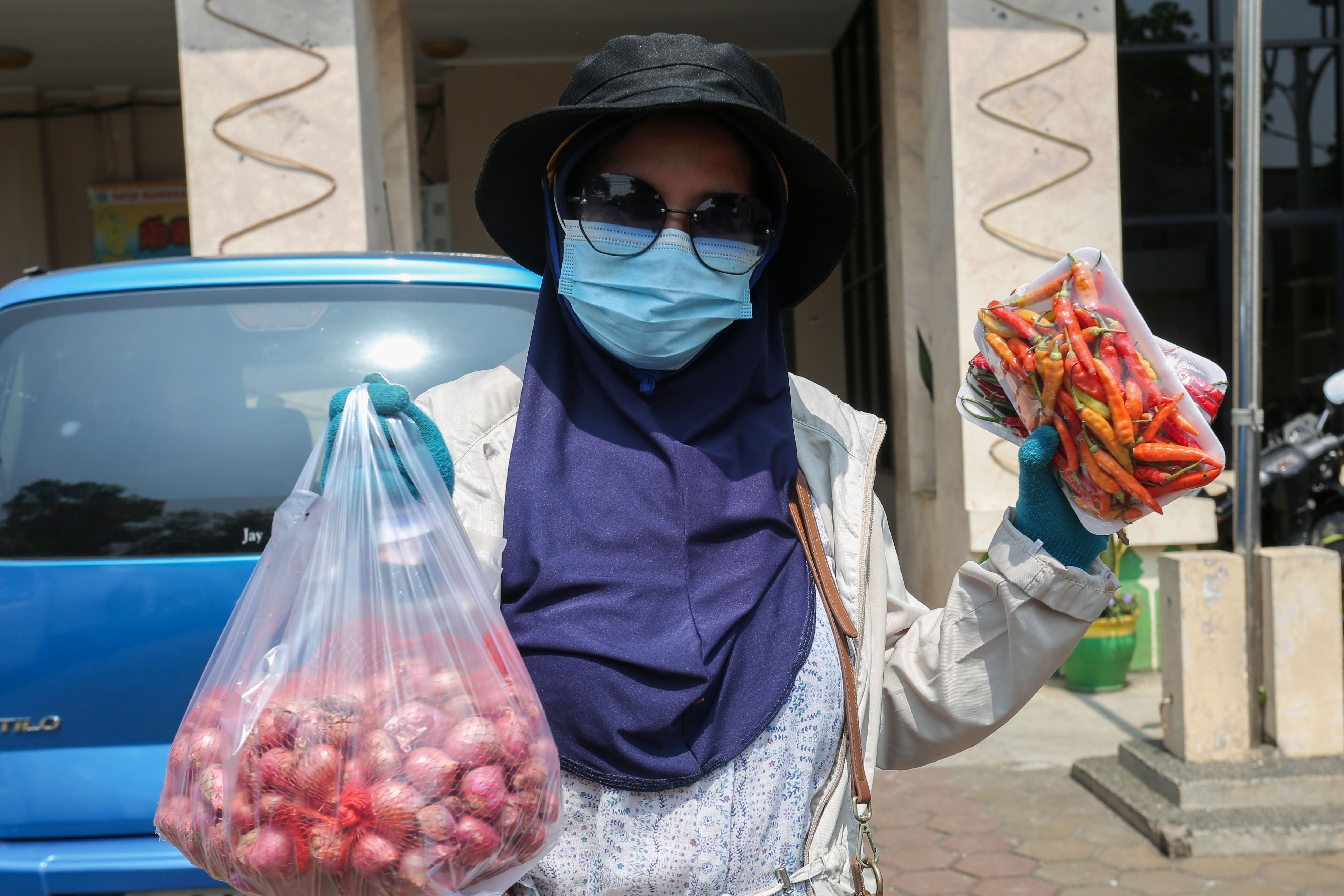 Maryani (43) menunjukkan cabai rawit merah dan bawang merah yang dibeli di Gerakan Pangan Murah di Kantor Kelurahan Kalisari, Jakarta Timur, Selasa (7/5/2024). Untuk menstabilkan harga pangan khususnya bawang merah, Badan Pangan Nasional bersama dengan Kementerian Pertanian menggelar \