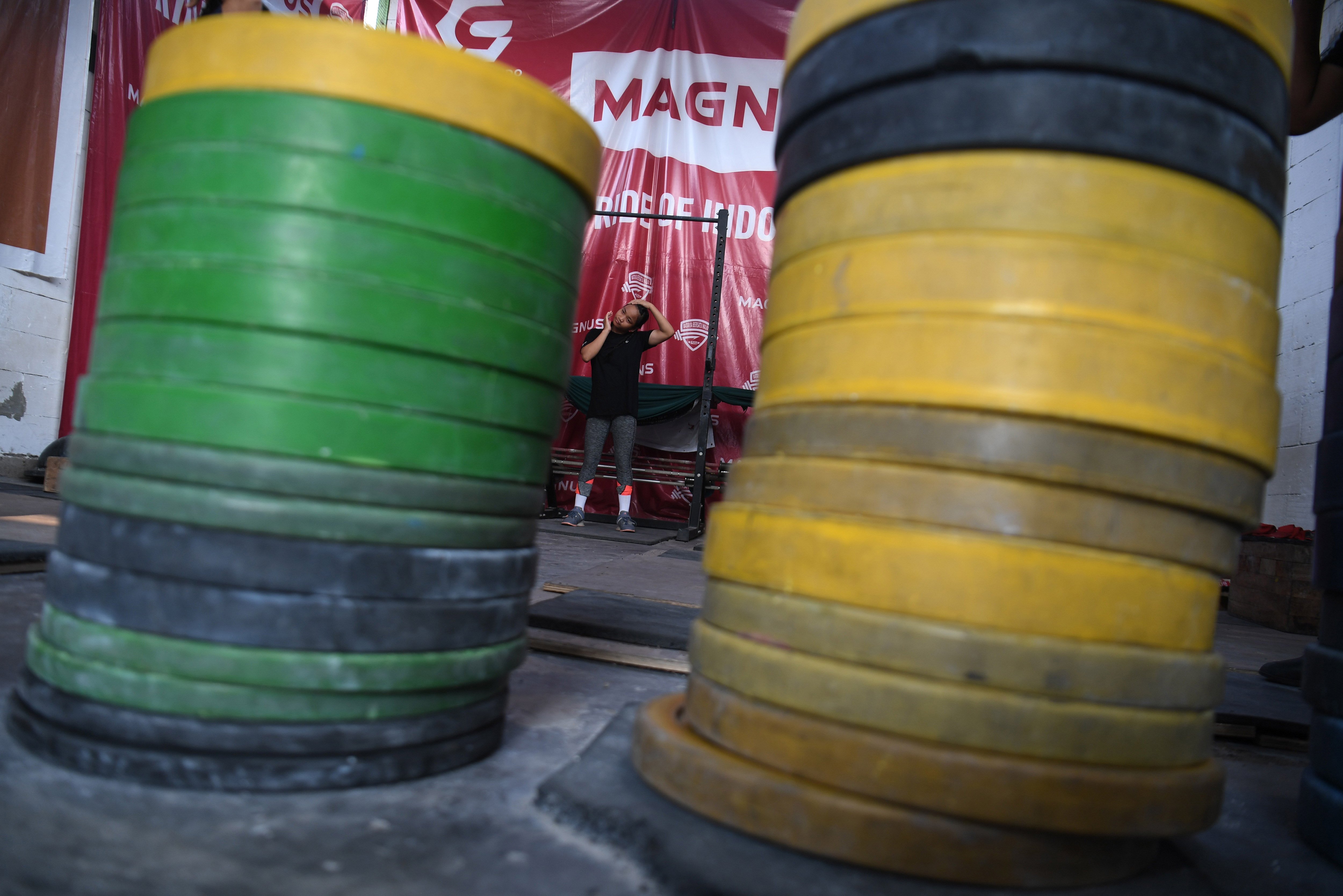 Seorang lifter muda melakukan pemanasan di 6221 Weightlifting Academy, Parungpanjang, Bogor, Jawa Barat.