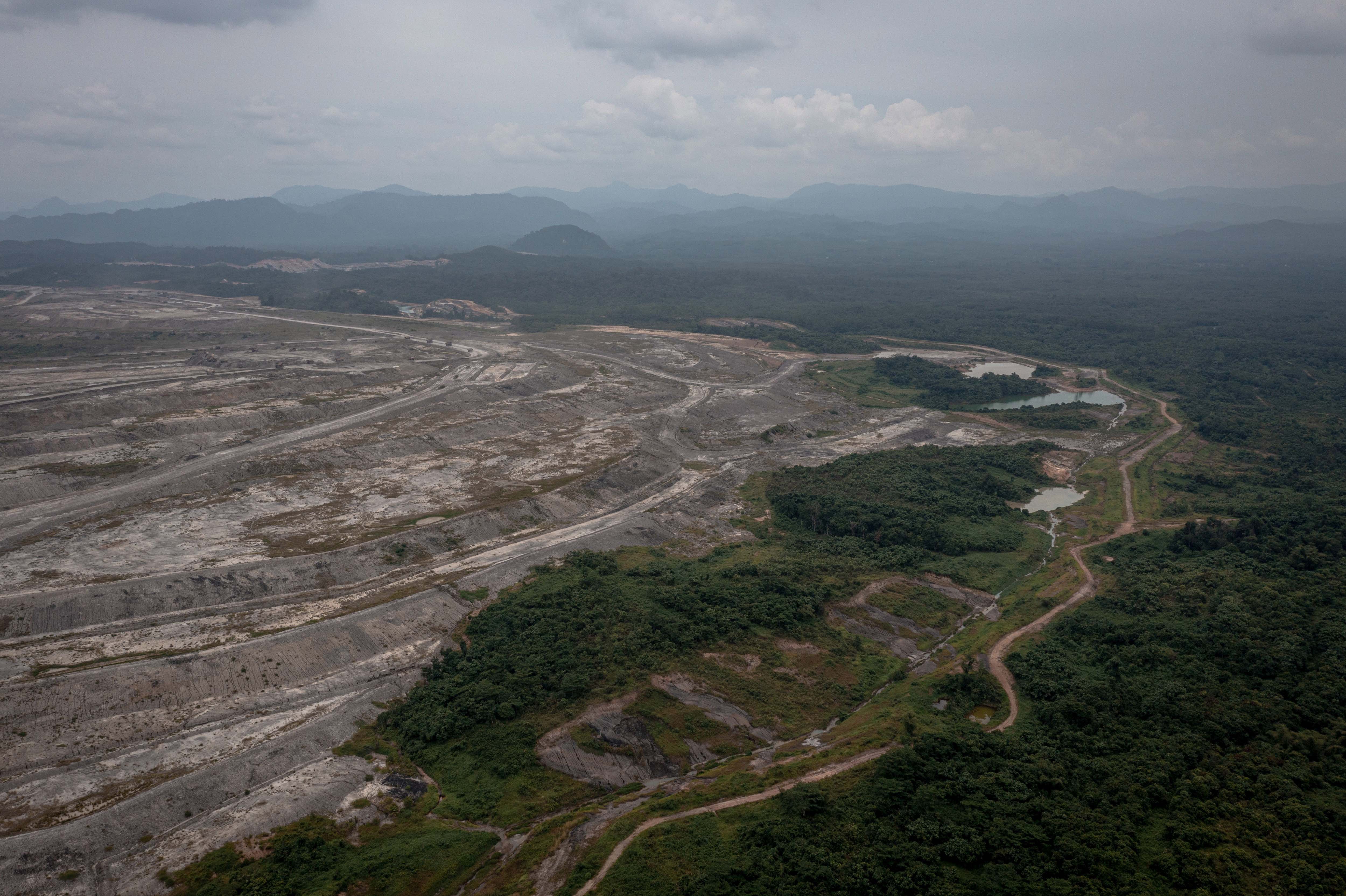 Foto udara salah satu tambang batu bara dengan latar belakang Pegunungan Meratus di Kalimantan Selatan.
