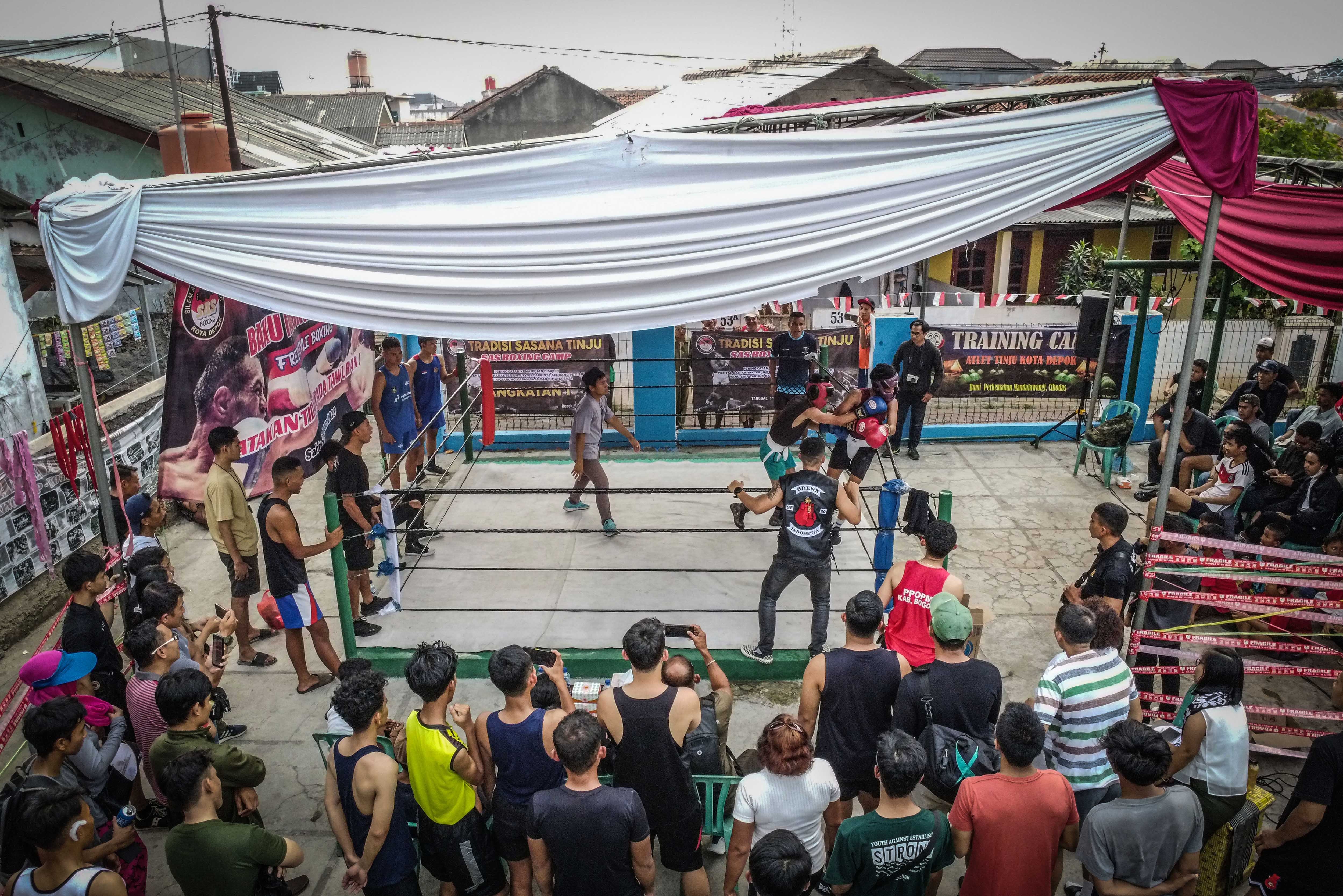 Sejumlah penonton menyaksikan pertandingan tinju yang diselenggarakan di SAS Boxing Depok, Jawa Barat.