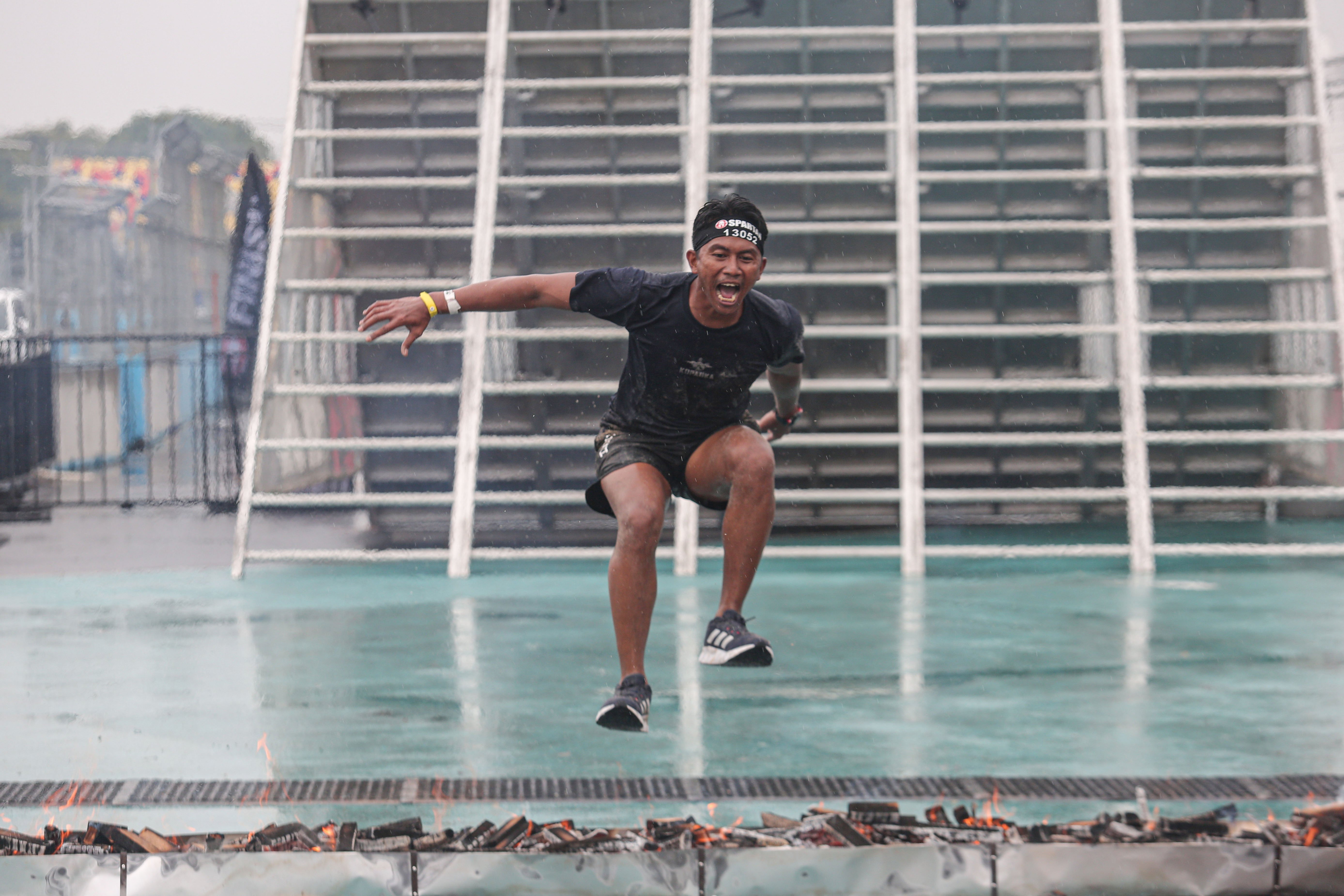 Seorang peserta melompati bara api saat mengikuti perlombaan lari halang rintang (Spartan Race) di Jakarta International ePrix Circuit, Jakarta Utara, Sabtu (25/5/2024). Pertandingan yang pertama kali digelar di Indonesia ini diikuti kurang lebih 1000 peserta yang memperlombakan Sprint 5k dengan 20 halang rintang yang terdiri dari kategori Pro Championship, Age Group Championship dan Open Category.