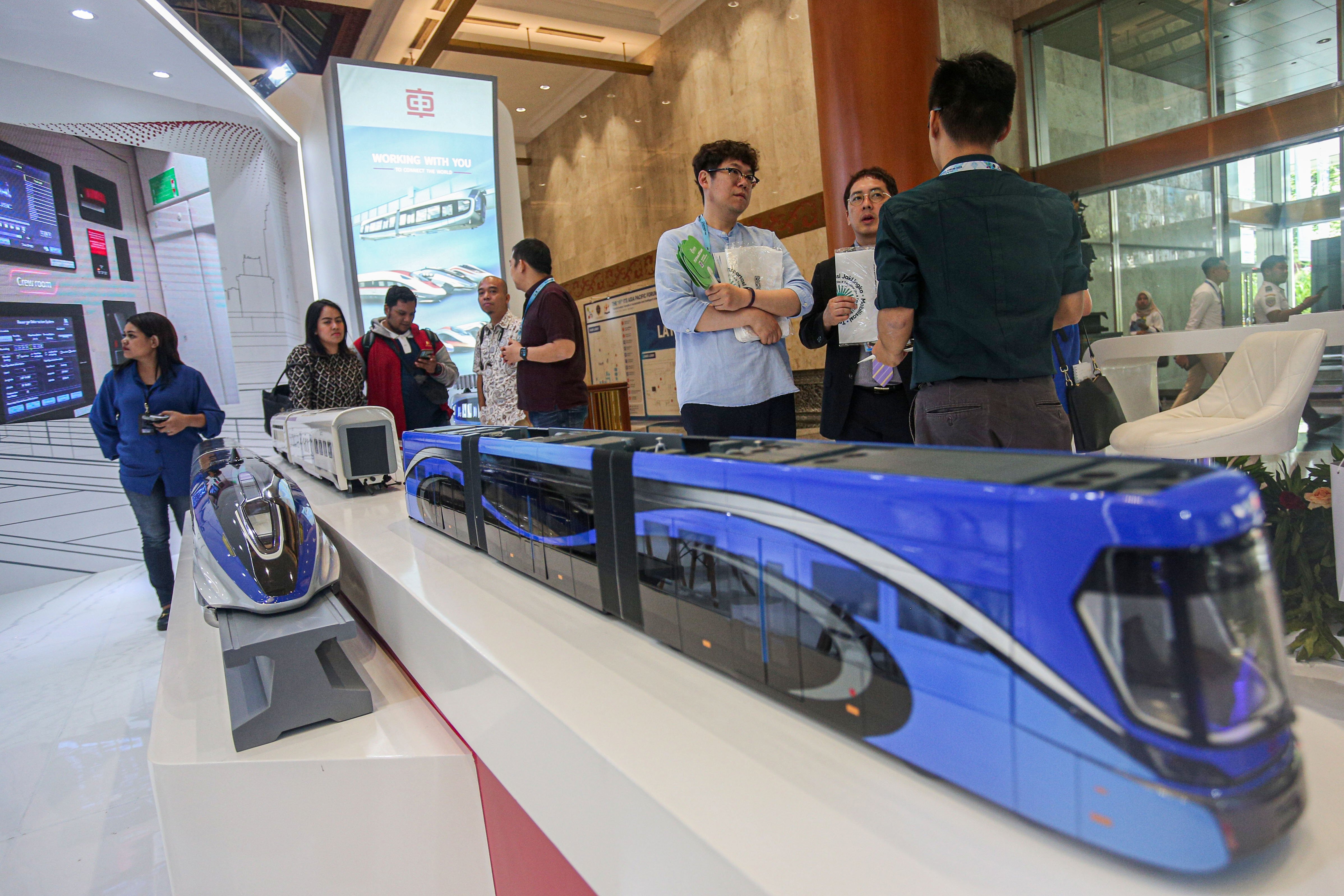 Pengunjung melihat miniatur kereta buatan China pada pameran Intelligent Transport System (ITS) Asia Pacific Forum 2024 di Jakarta Convention Center (JCC), Jakarta, Rabu (29/5/2024). Dengan mengusung tema \