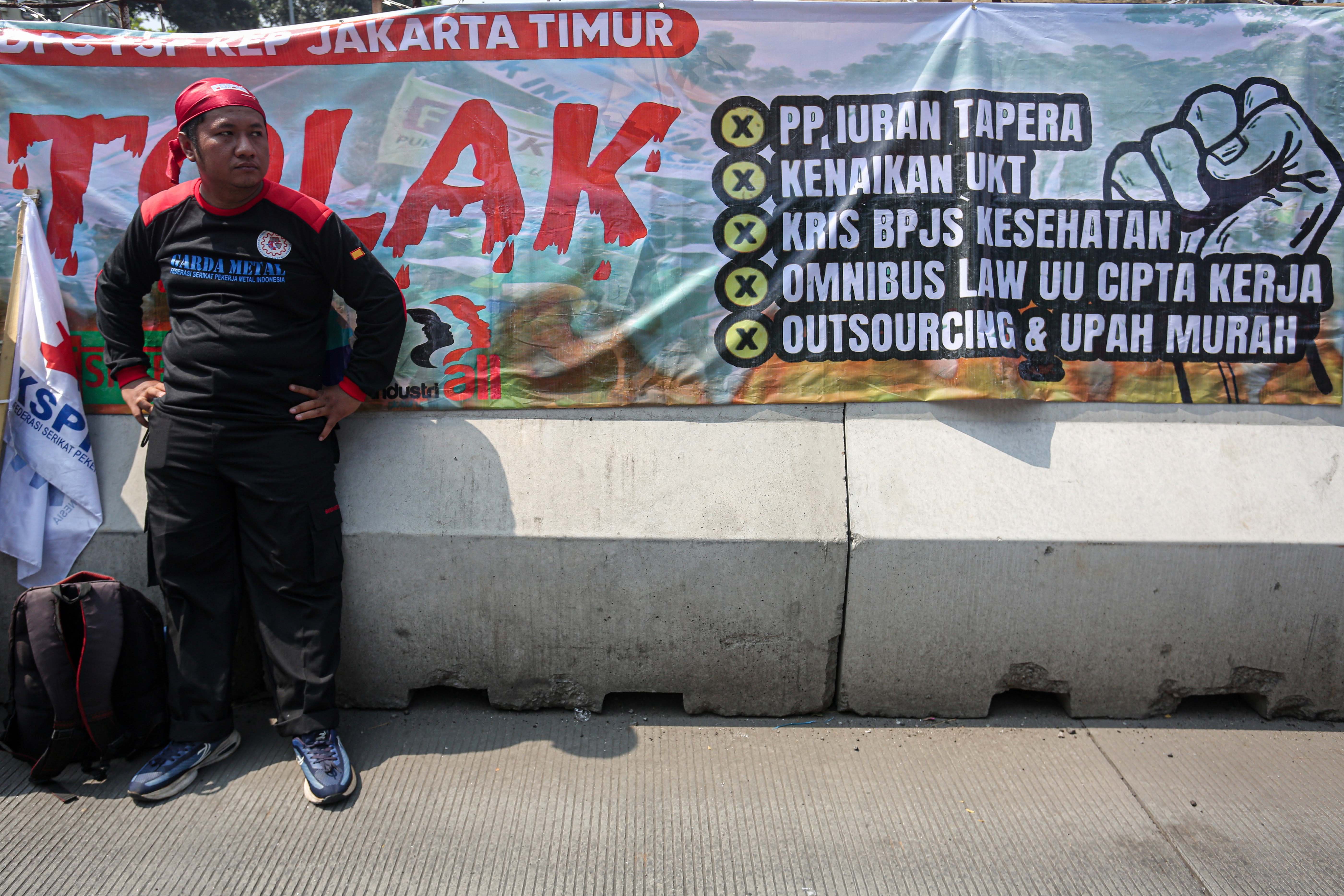 Seorang buruh mengikuti aksi demonstrasi di kawasan Patung Kuda, Jakarta, Kamis (6/6/2024). Dalam aksi tersebut buruh menolak Peraturan Pemerintah Nomor 21 Tahun 2024 tentang kewajiban membayar iuran tabungan perumahan rakyat atau Tapera yang dinilai dapat membebani lantaran mayoritas iuran dibayarkan oleh buruh.