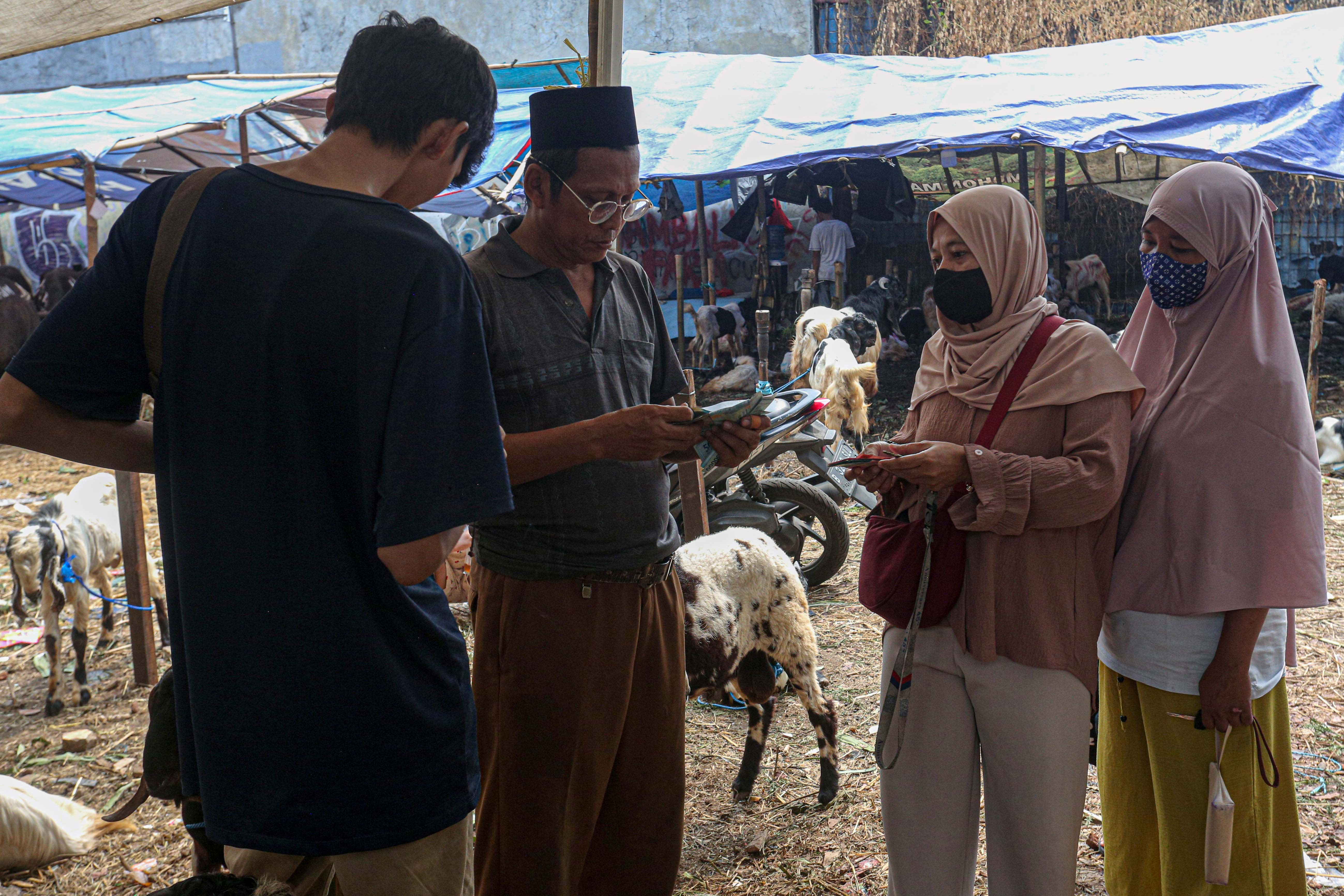 Warga membeli kambing yang dijual di lapak hewan kurban di Kampung Makasar, Jakarta Timur, Rabu (12/6/2024). Menjelang Hari Raya Idul Adha 1445 H, pedagang menyatakan penjualan hewan kurban mengalami peningkatan hingga 50 persen dengan harga jual Rp3 juta hingga Rp5,5 juta per ekor kambing yang tergantung dari ukuran dan berat badan hewan.