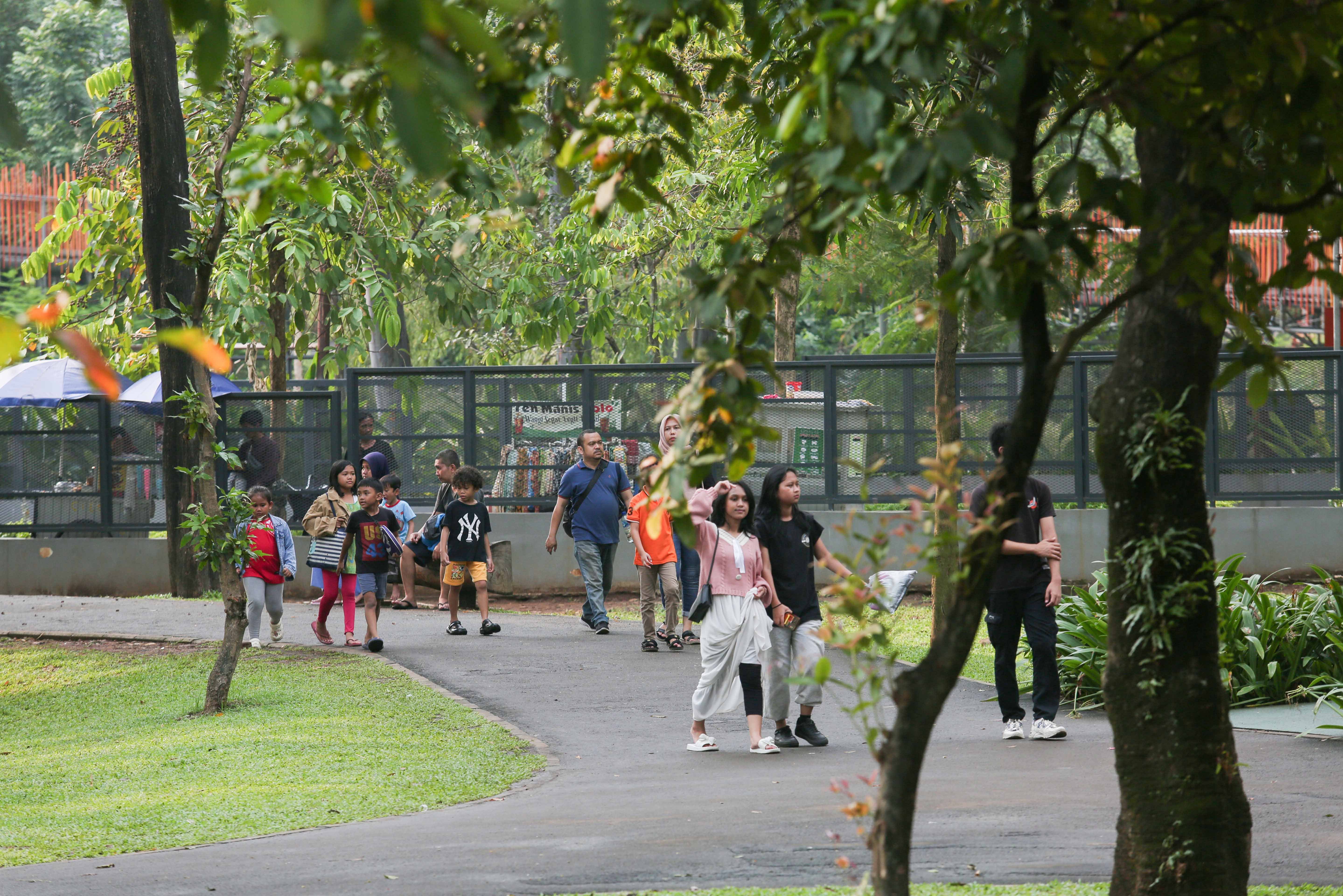 Sejumlah warga berjalan di kawasan Tebet Eco Park, Jakarta, Rabu (3/7/2024). Taman seluas 7,3 hektar yang dikelilingi oleh pepohonan rindang dan menyajikan udara segar ini menjadi salah satu tempat wisata alternatif warga Jakarta dalam menghabiskan waktu liburan sekolah.