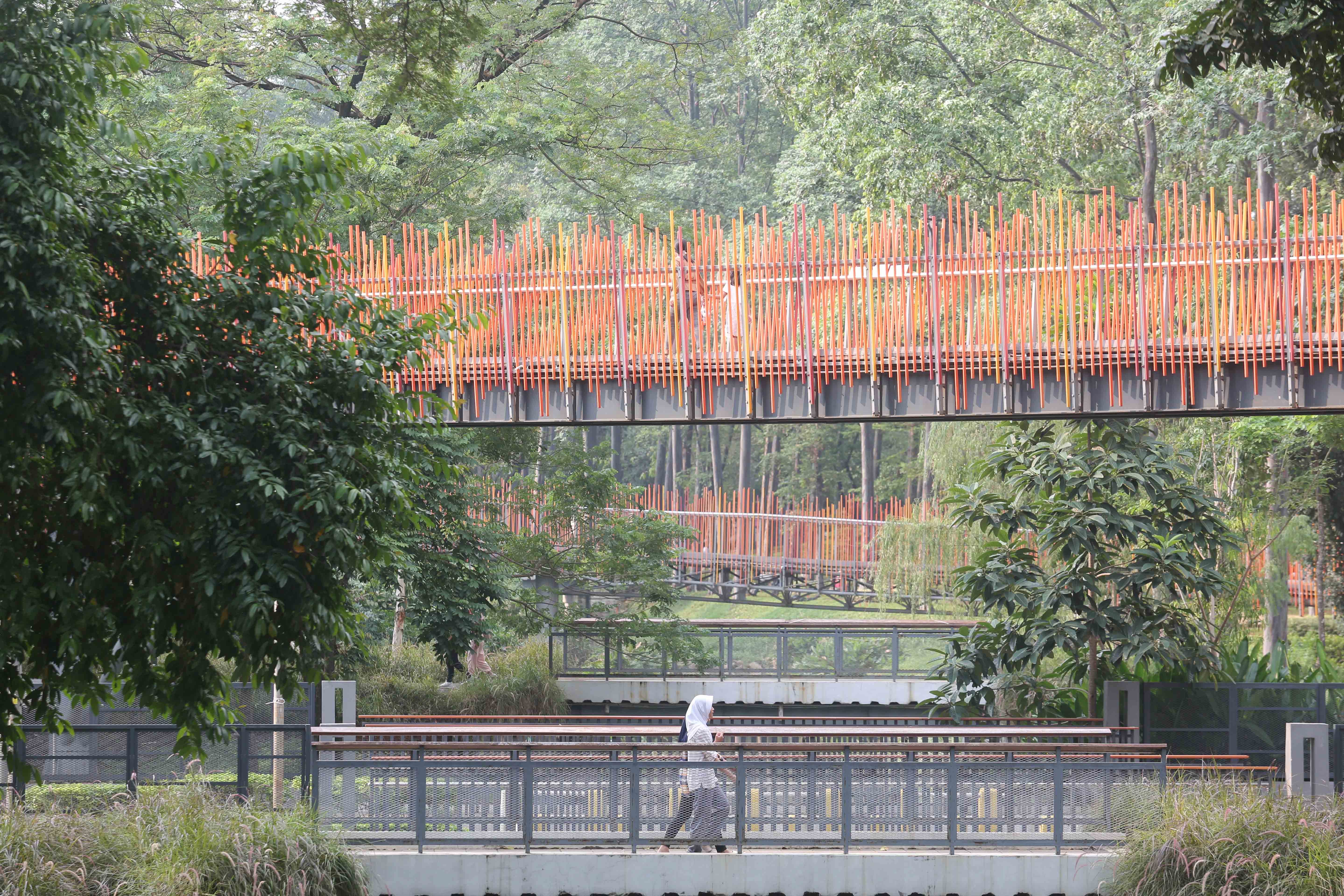 Sejumlah warga berjalan di kawasan Tebet Eco Park, Jakarta, Rabu (3/7/2024). Taman seluas 7,3 hektar yang dikelilingi oleh pepohonan rindang dan menyajikan udara segar ini menjadi salah satu tempat wisata alternatif warga Jakarta dalam menghabiskan waktu liburan sekolah.