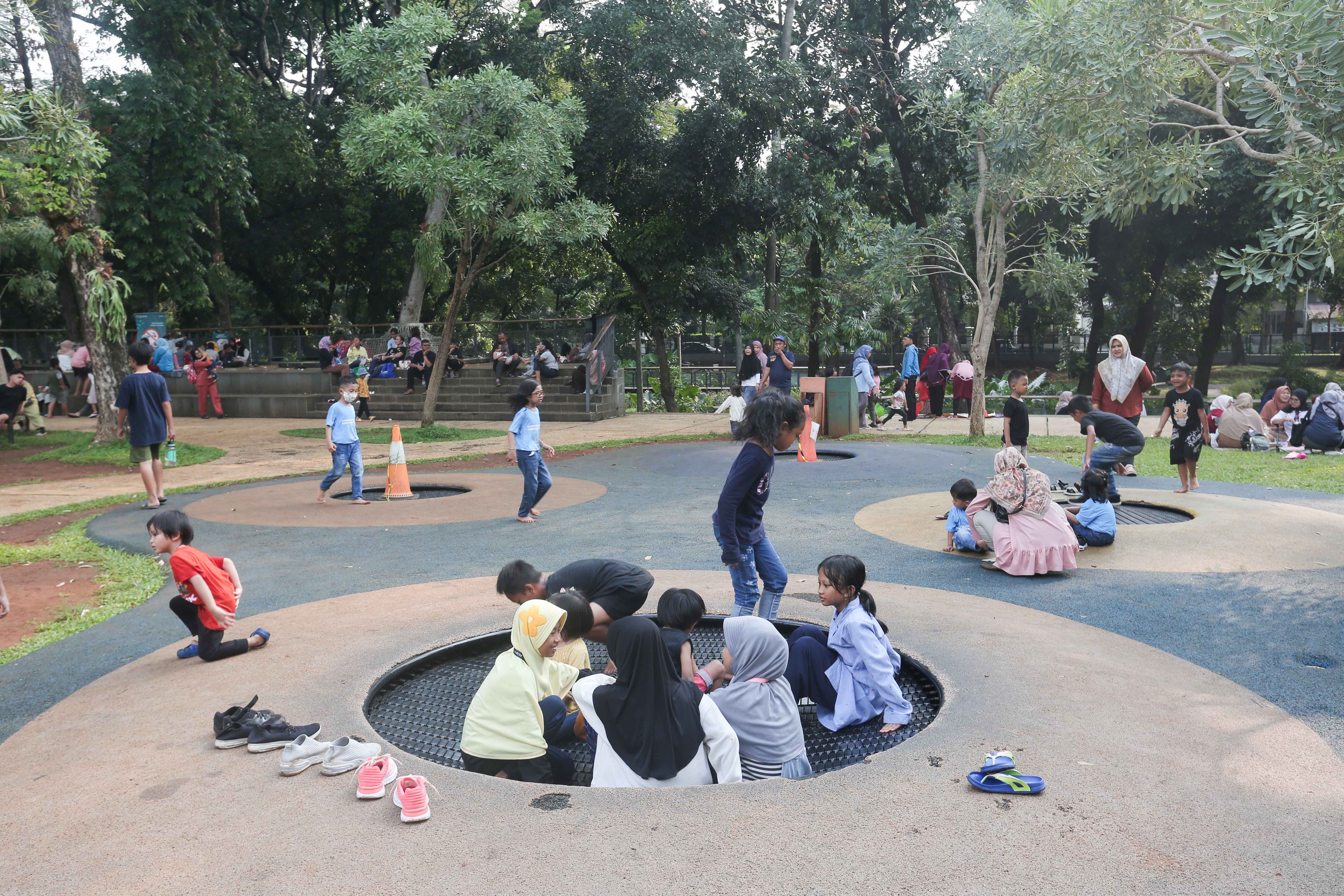 Anak-anak bermain trampolin di taman bermain Tebet Eco Park, Jakarta, Rabu (3/7/2024). Taman seluas 7,3 hektar yang dikelilingi oleh pepohonan rindang dan menyajikan udara segar ini menjadi salah satu tempat wisata alternatif warga Jakarta dalam menghabiskan waktu liburan sekolah.