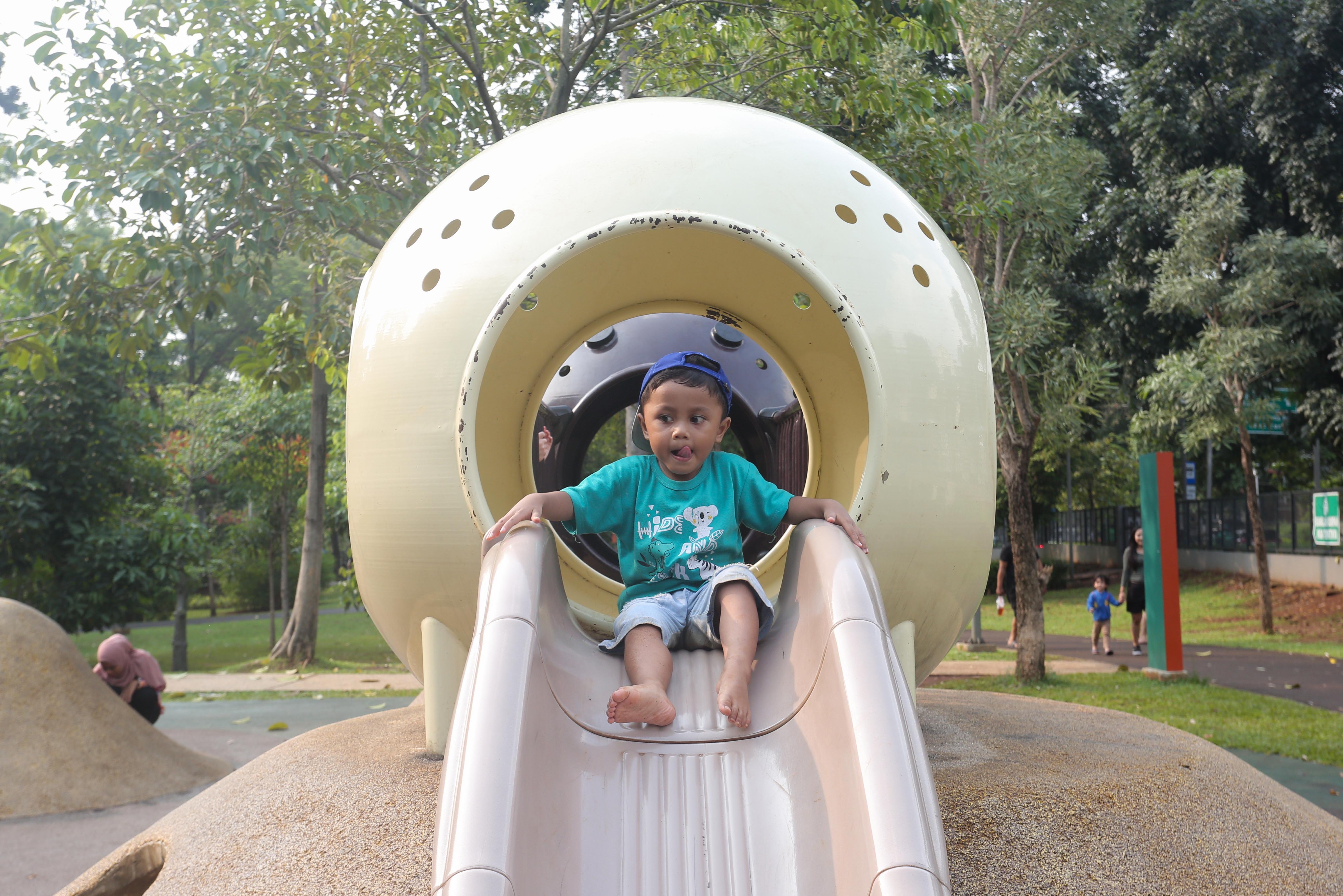 Seorang anak bermain perosotan di taman bermain Tebet Eco Park, Jakarta, Rabu (3/7/2024). Taman seluas 7,3 hektar yang dikelilingi oleh pepohonan rindang dan menyajikan udara segar ini menjadi salah satu tempat wisata alternatif warga Jakarta dalam menghabiskan waktu liburan sekolah.