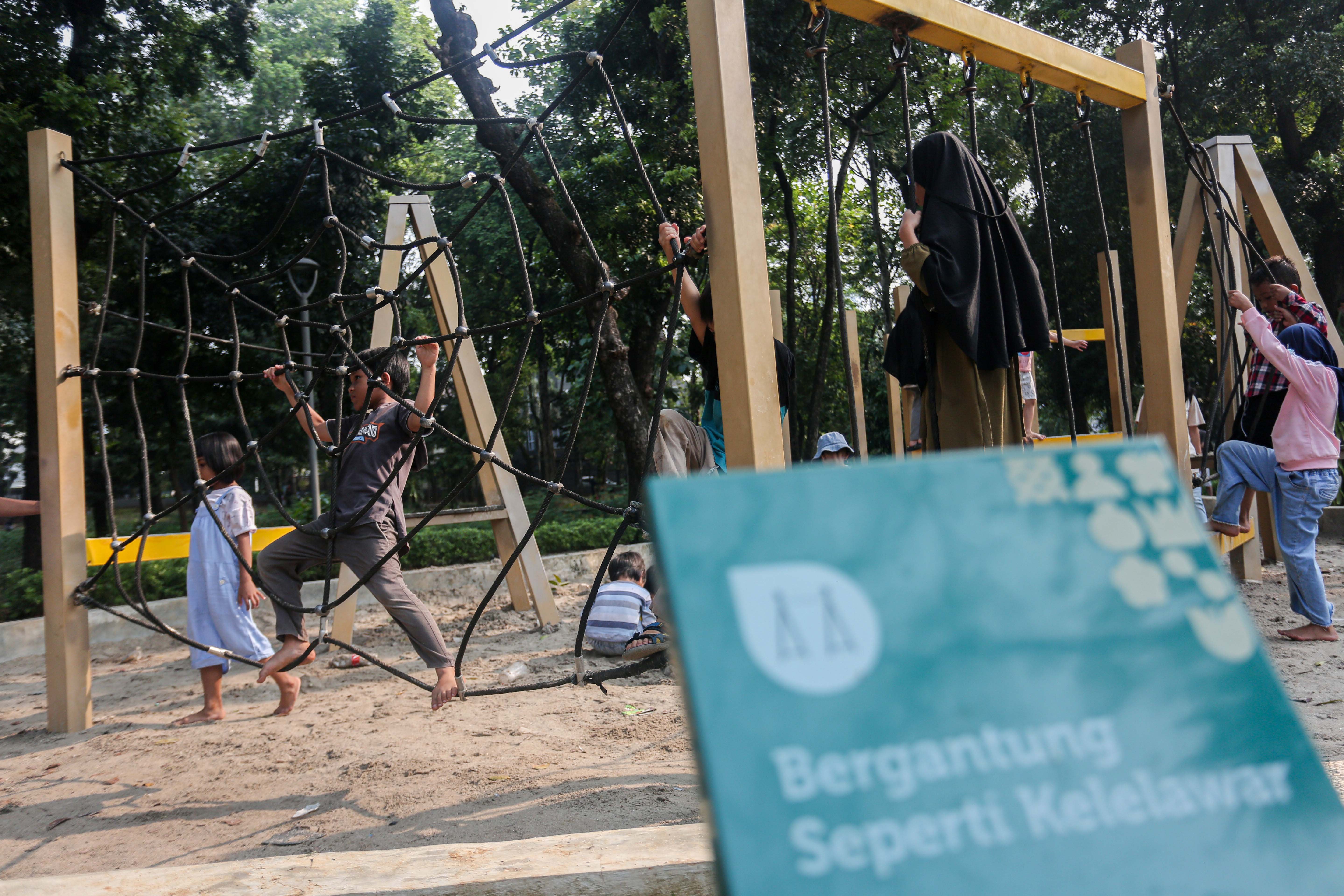 Anak-anak bermain panjat tali di taman bermain Tebet Eco Park, Jakarta, Rabu (3/7/2024). Taman seluas 7,3 hektar yang dikelilingi oleh pepohonan rindang dan menyajikan udara segar ini menjadi salah satu tempat wisata alternatif warga Jakarta dalam menghabiskan waktu liburan sekolah.