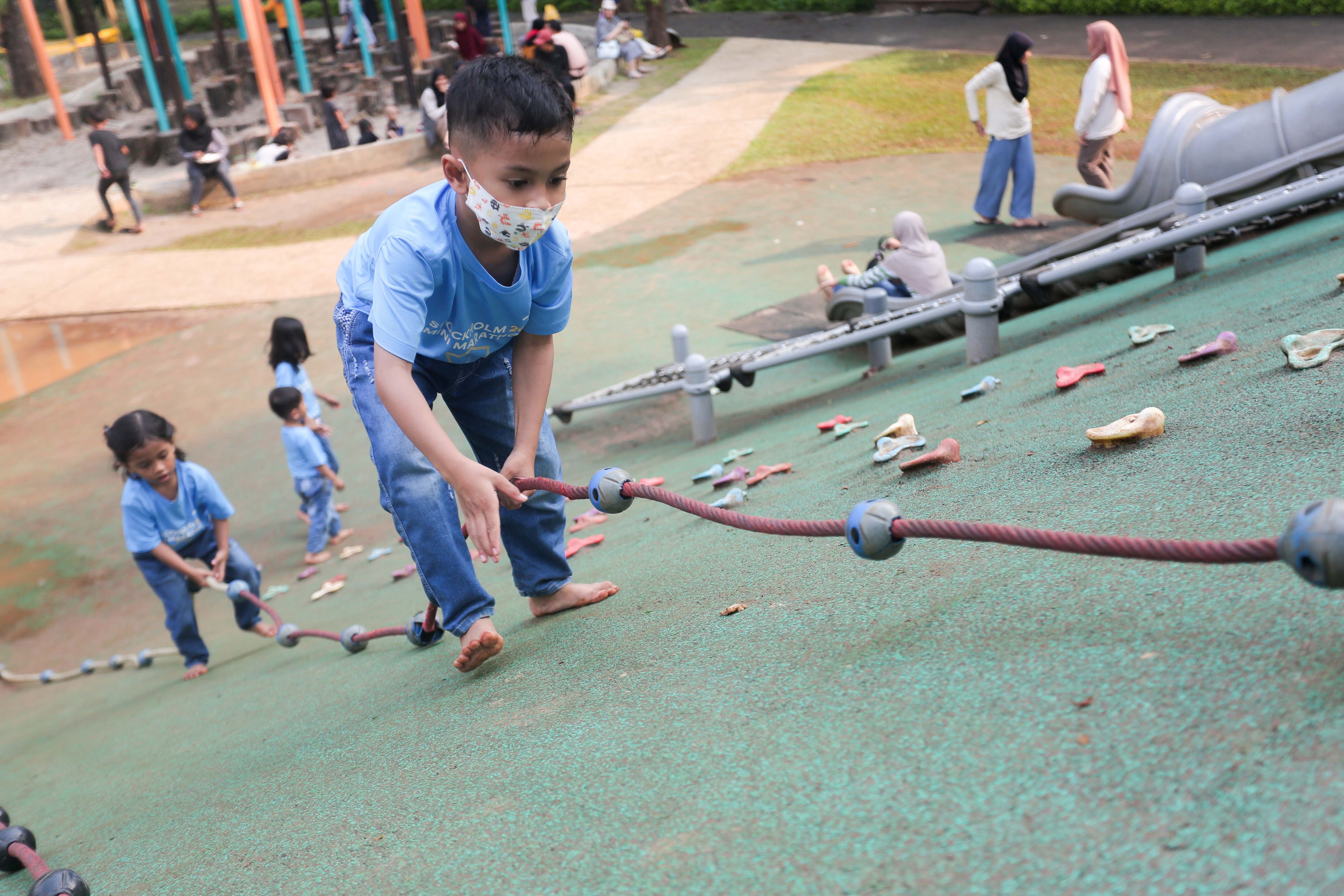 Anak-anak bermain panjat tali di taman bermain Tebet Eco Park, Jakarta, Rabu (3/7/2024). Taman seluas 7,3 hektar yang dikelilingi oleh pepohonan rindang dan menyajikan udara segar ini menjadi salah satu tempat wisata alternatif warga Jakarta dalam menghabiskan waktu liburan sekolah.