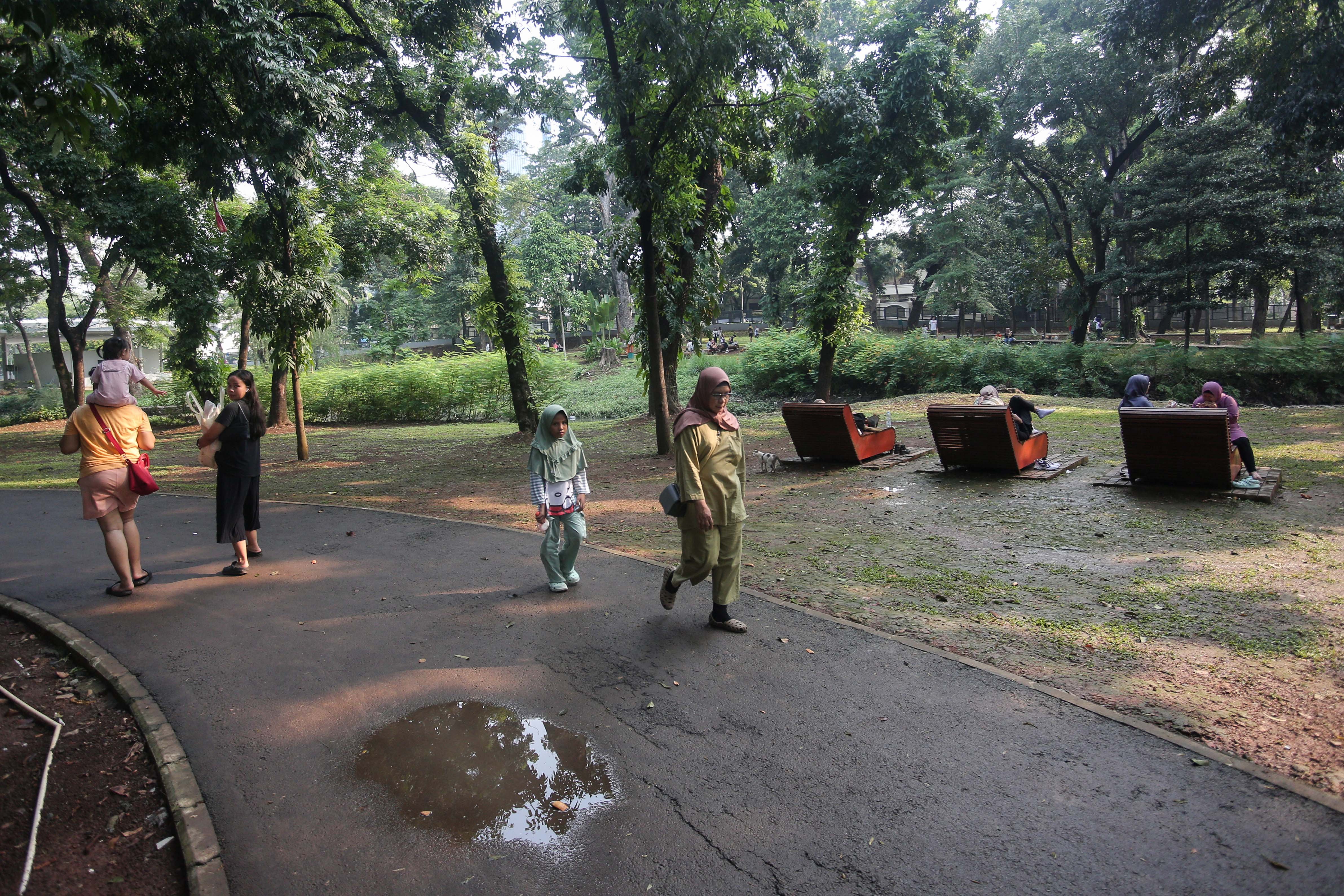 Sejumlah warga berjalan di kawasan Tebet Eco Park, Jakarta, Rabu (3/7/2024). Taman seluas 7,3 hektar yang dikelilingi oleh pepohonan rindang dan menyajikan udara segar ini menjadi salah satu tempat wisata alternatif warga Jakarta dalam menghabiskan waktu liburan sekolah.
