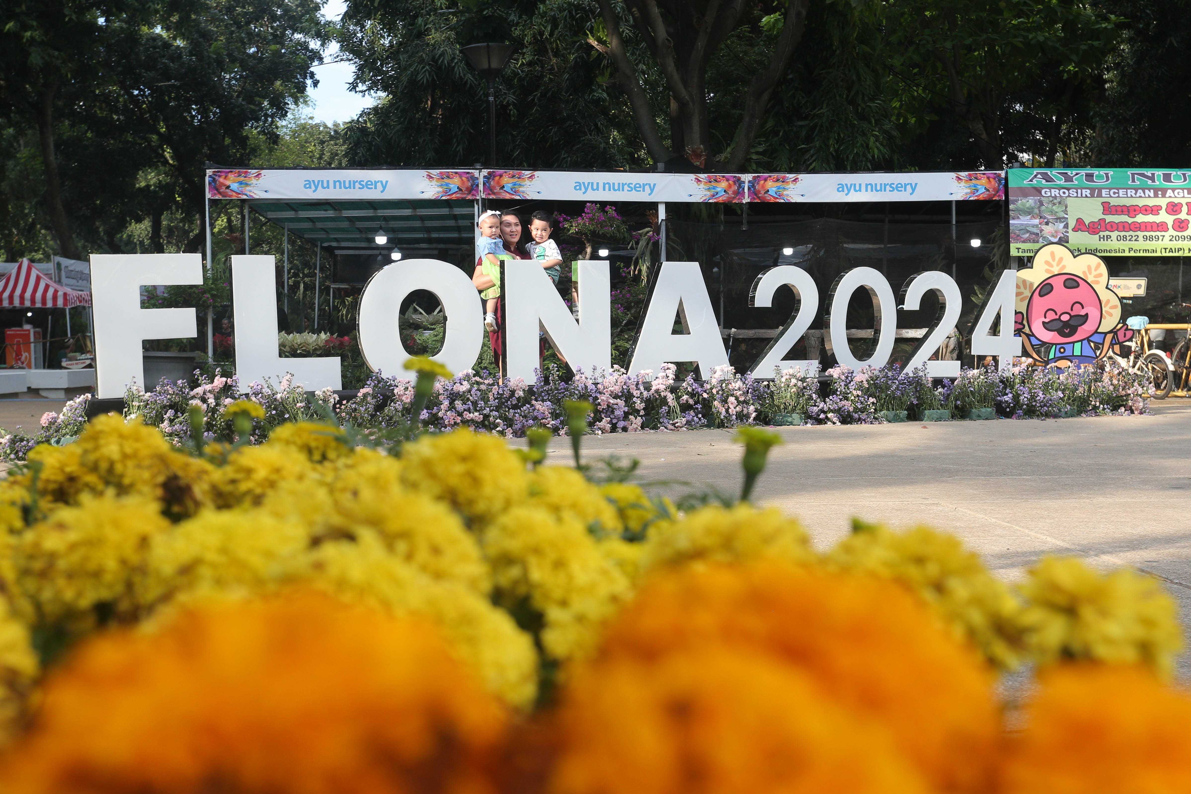 Pengunjung berfoto dengan instalasi yang bertuliskan FLONA 2024 saat pameran Flona di Lapangan Banteng, Jakarta, senin (8/7/2024). Pameran yang mengusung tema Jakarta Global Hijau Mempesona ini menampilkan berbagai jenis tanaman hias, hewan peliharaan dan kuliner nusantara yang berlangsung hingga 2 Agustus 2024.