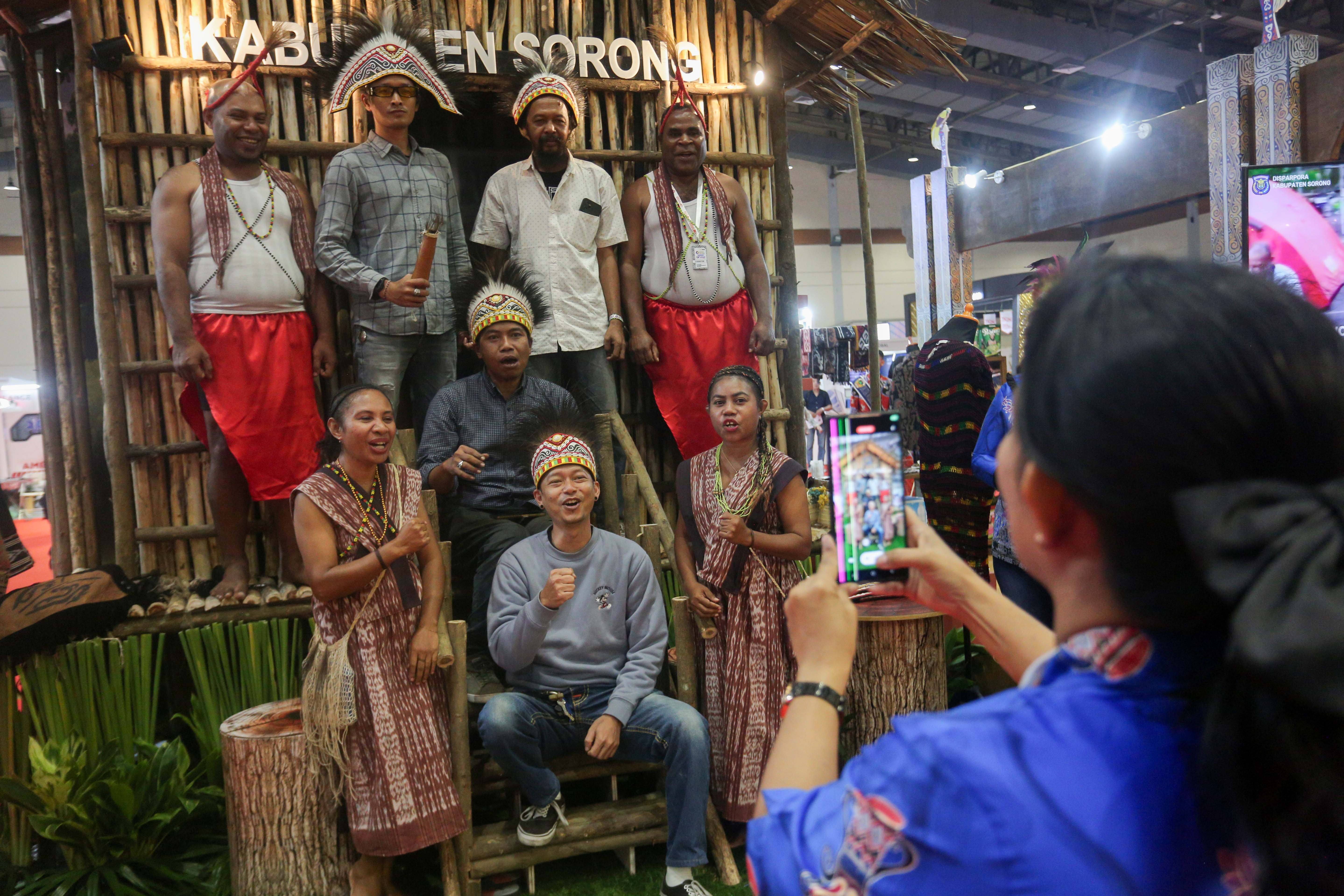 Pengunjung berfoto di stan Kabupaten Sorong saat pameran Asosiasi Kabupaten Seluruh Indonesia (Apkasi) Otonomi Expo 2024 di Jakarta Convention Center (JCC), Senayan, Jakarta, Rabu (10/7/2024). Pameran yang mengangkat tema \