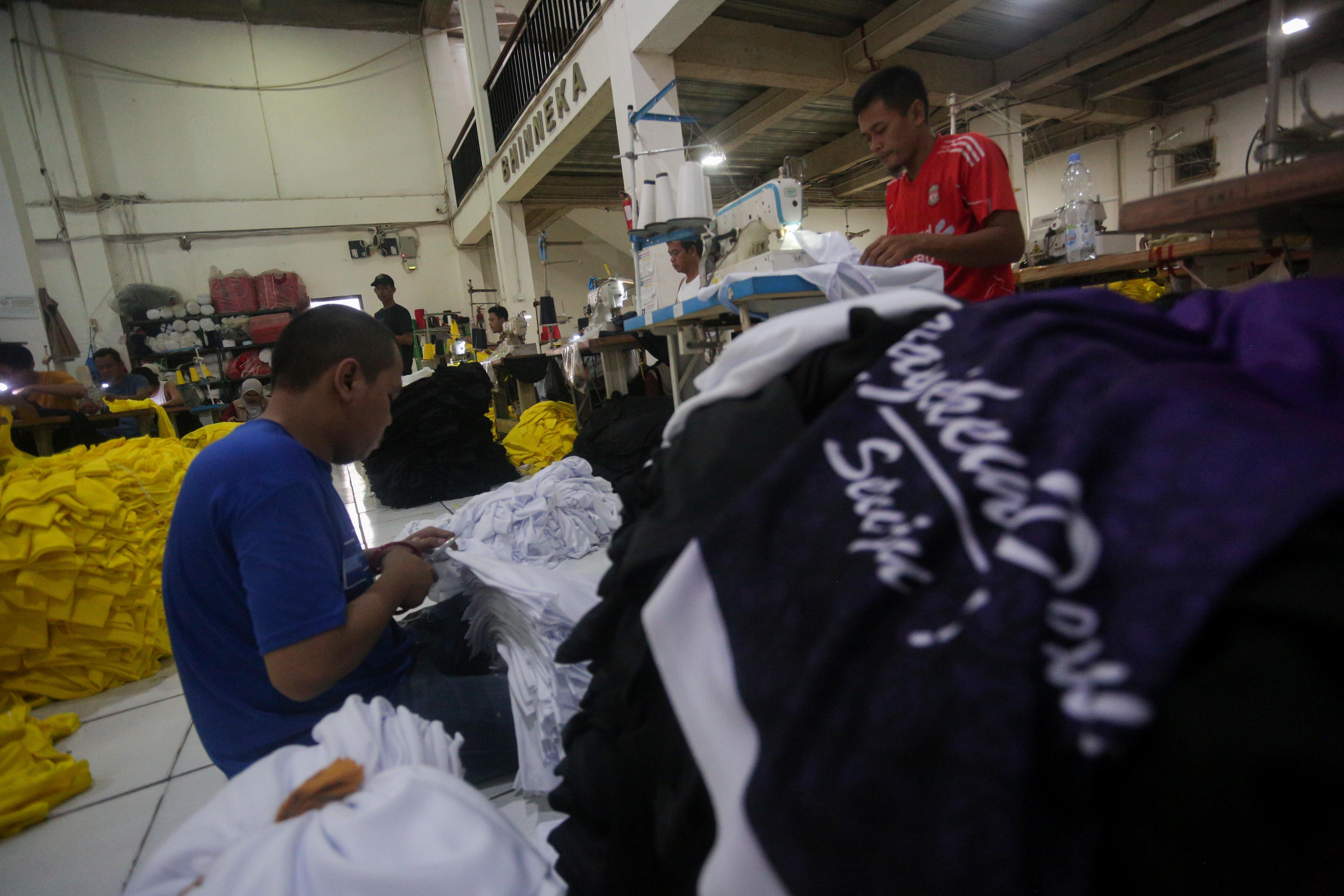 Pekerja menyelesaikan pembuatan kaos di konveksi Sinergi Adv Nusantara di kawasan Srengseng Sawah, Jakarta Selatan, Rabu (17/7/2024). Di tengah maraknya produk impor di pasaran yang mengakibatkan industri tekstil dalam negeri terpuruk, usaha konveksi masih bertahan dengan memenuhi pesanan sekitar 500 ribu kaos per bulan.