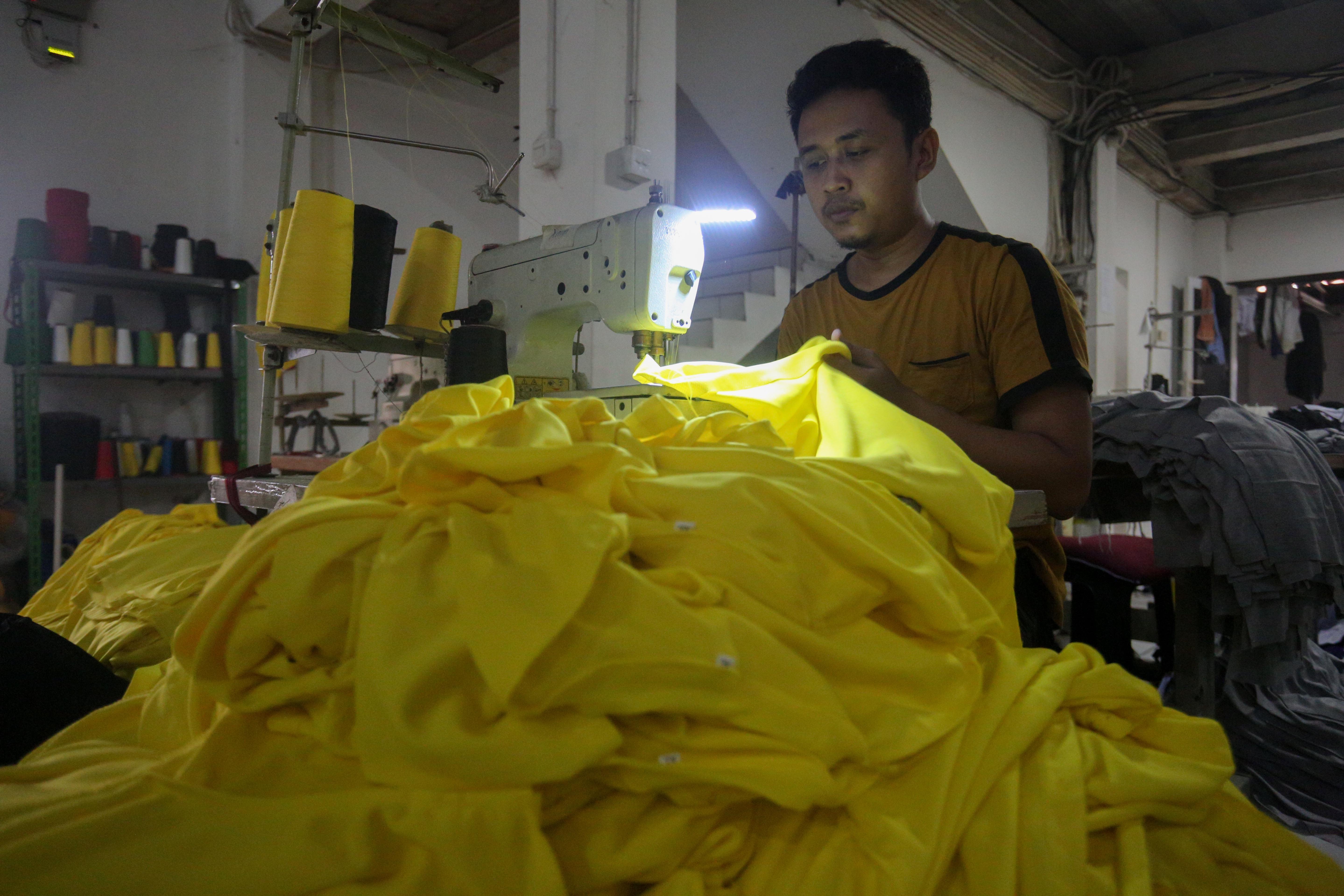 Pekerja menyelesaikan pembuatan kaos di konveksi Sinergi Adv Nusantara di kawasan Srengseng Sawah, Jakarta Selatan, Rabu (17/7/2024). Di tengah maraknya produk impor di pasaran yang mengakibatkan industri tekstil dalam negeri terpuruk, usaha konveksi masih bertahan dengan memenuhi pesanan sekitar 500 ribu kaos per bulan.