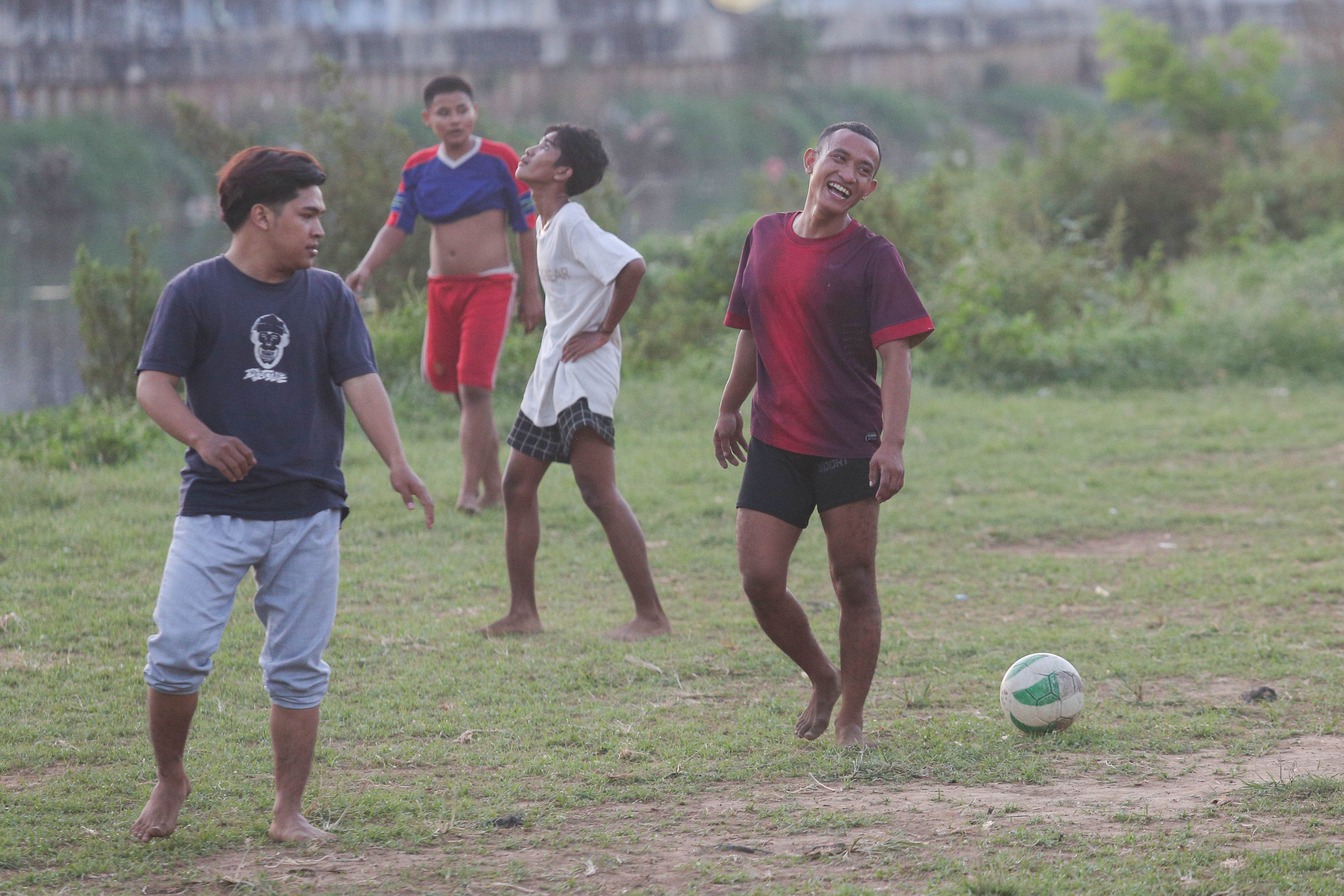 Sejumlah warga bermain sepak bola di bantaran Kali Ciliwung di Jalan Setia Kawan III, Duri Pulo, Jakarta Pusat, Selasa (16/7/2024). Terbatasnya ruang terbuka hijau (RTH) di sekitar wilayah tersebut membuat warga memanfaatkan lahan kosong di bantaran kali untuk bermain sepak bola.