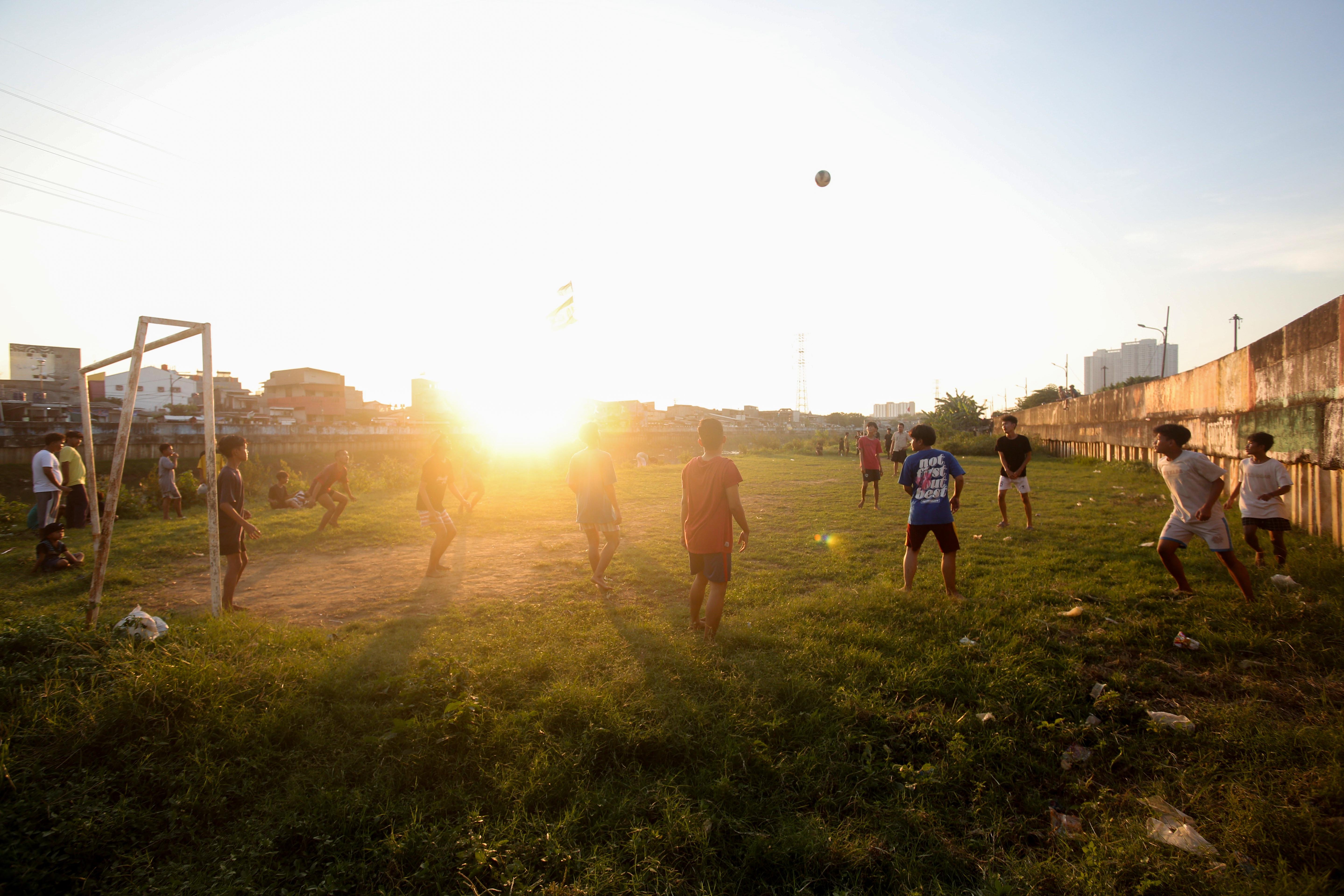 Sejumlah warga bermain sepak bola di bantaran Kali Ciliwung di Jalan Setia Kawan III, Duri Pulo, Jakarta Pusat, Selasa (16/7/2024). Terbatasnya ruang terbuka hijau (RTH) di sekitar wilayah tersebut membuat warga memanfaatkan lahan kosong di bantaran kali untuk bermain sepak bola.