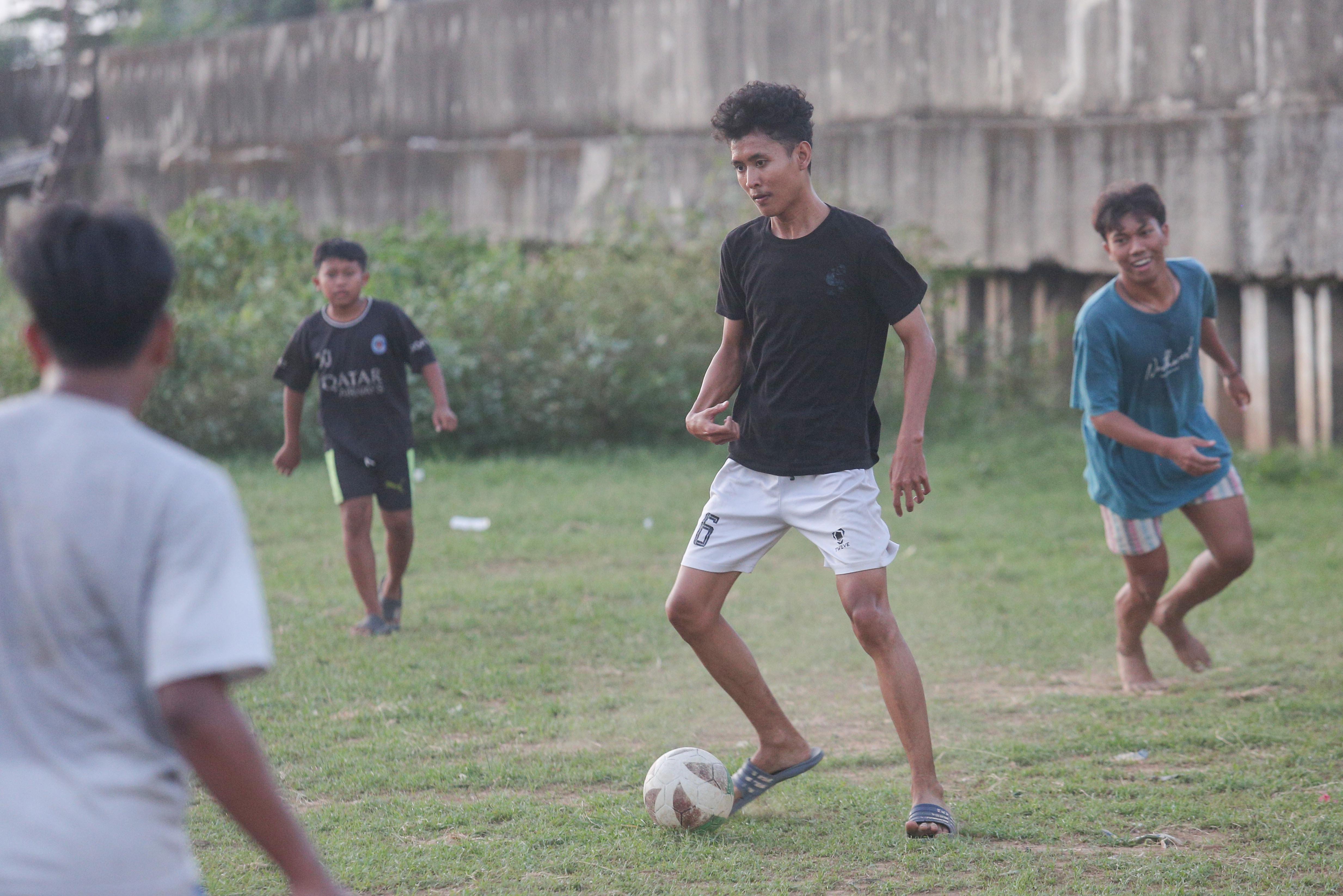 Sejumlah warga bermain sepak bola di bantaran Kali Ciliwung di Jalan Setia Kawan III, Duri Pulo, Jakarta Pusat, Selasa (16/7/2024). Terbatasnya ruang terbuka hijau (RTH) di sekitar wilayah tersebut membuat warga memanfaatkan lahan kosong di bantaran kali untuk bermain sepak bola.