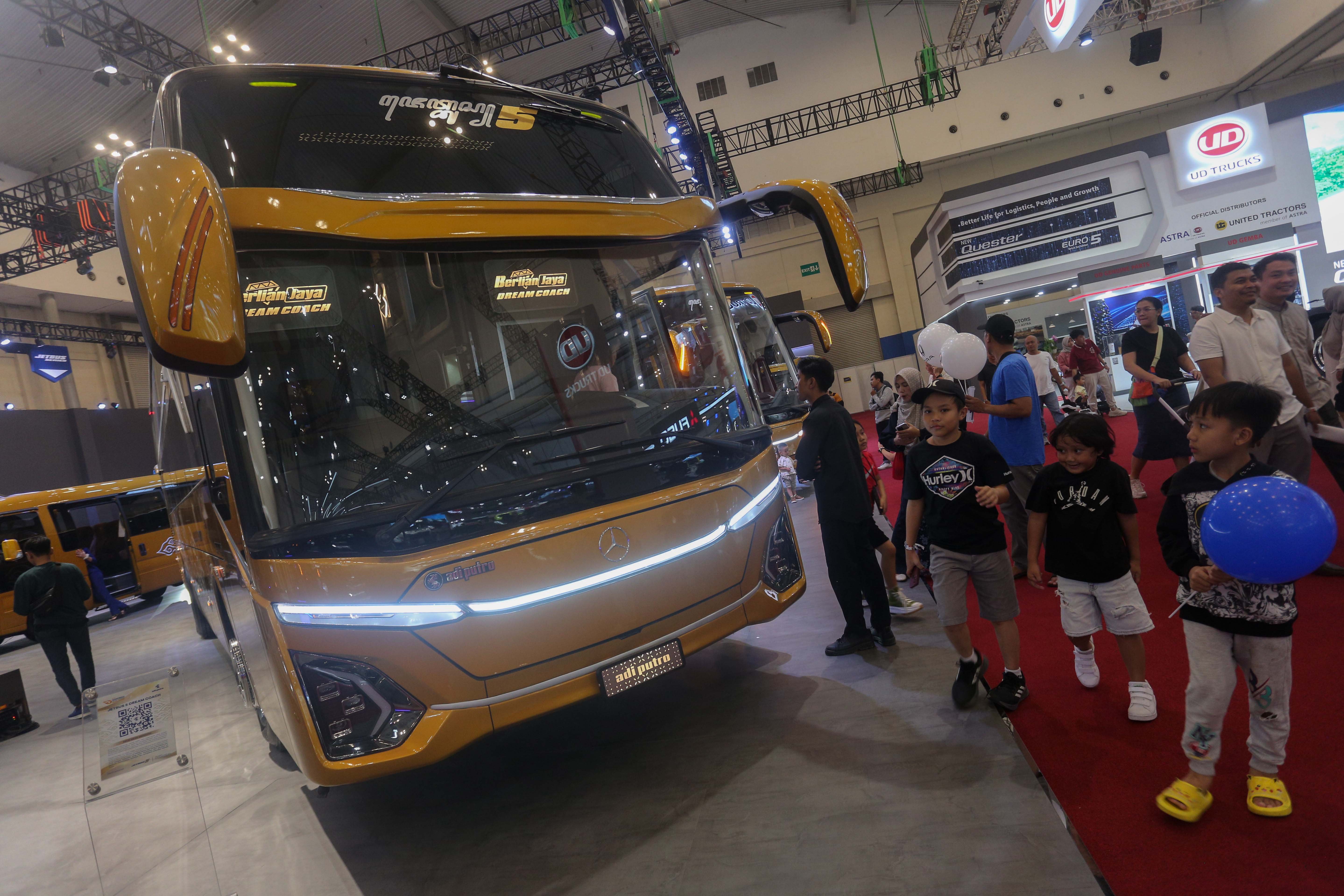 Pengunjung melihat bus yang dipamerkan di GAIKINDO Indonesia International Auto Show (GIIAS) 2024 di ICE BSD City, Kabupaten Tangerang, Banten, Jumat (19/7/2024). Pameran otomotif yang mengusung tema \