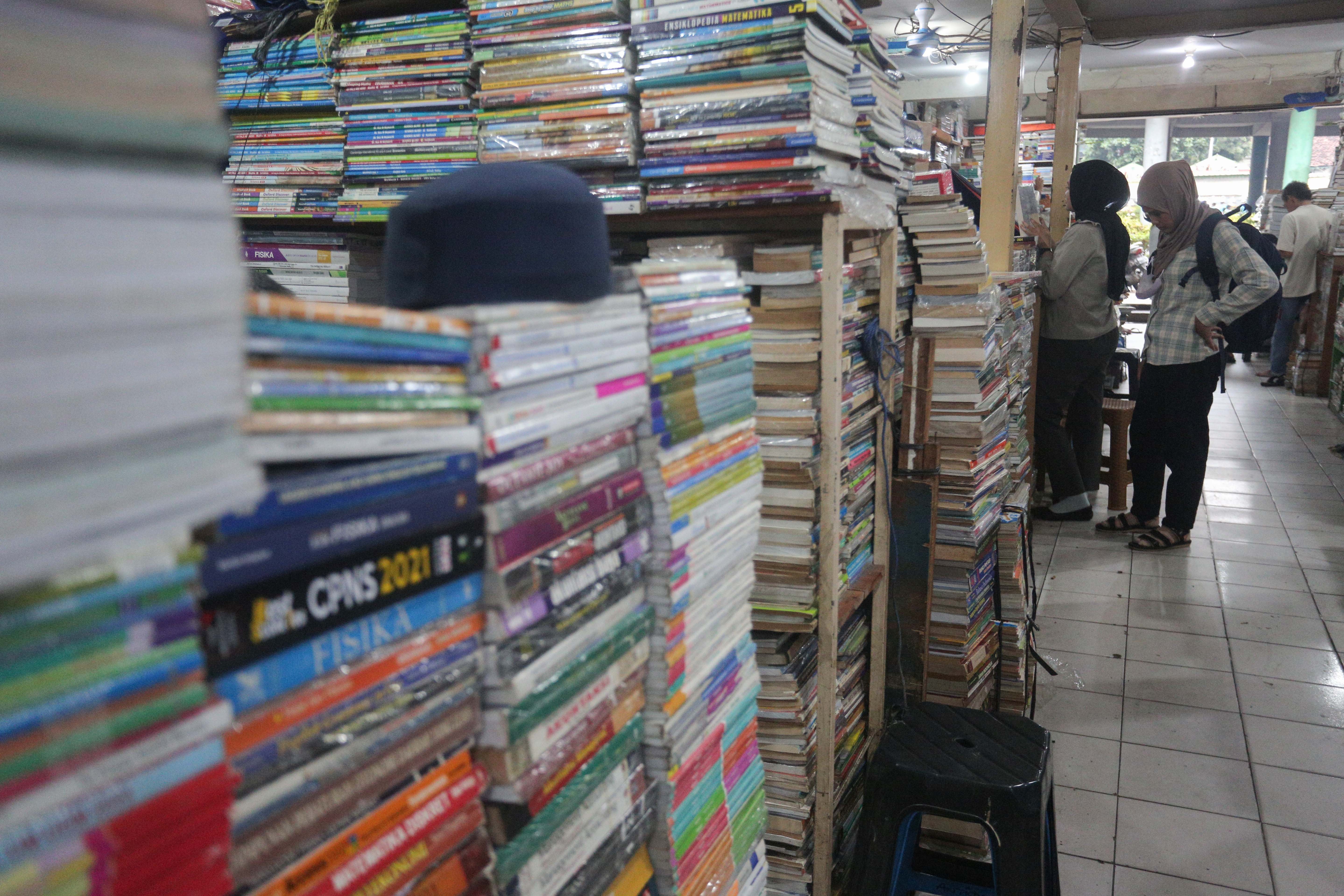 Pengunjung melihat buku yang dijual di Pasar Buku Kwitang, Jakarta Pusat, Rabu (24/7/2024). Berdasarkan penuturan pedagang, berkembangnya teknologi membuat masyarakat beralih dari membaca buku fisik ke digital sehingga penjualan buku di pasar tersebut mengalami penurunan yang cukup signifikan.