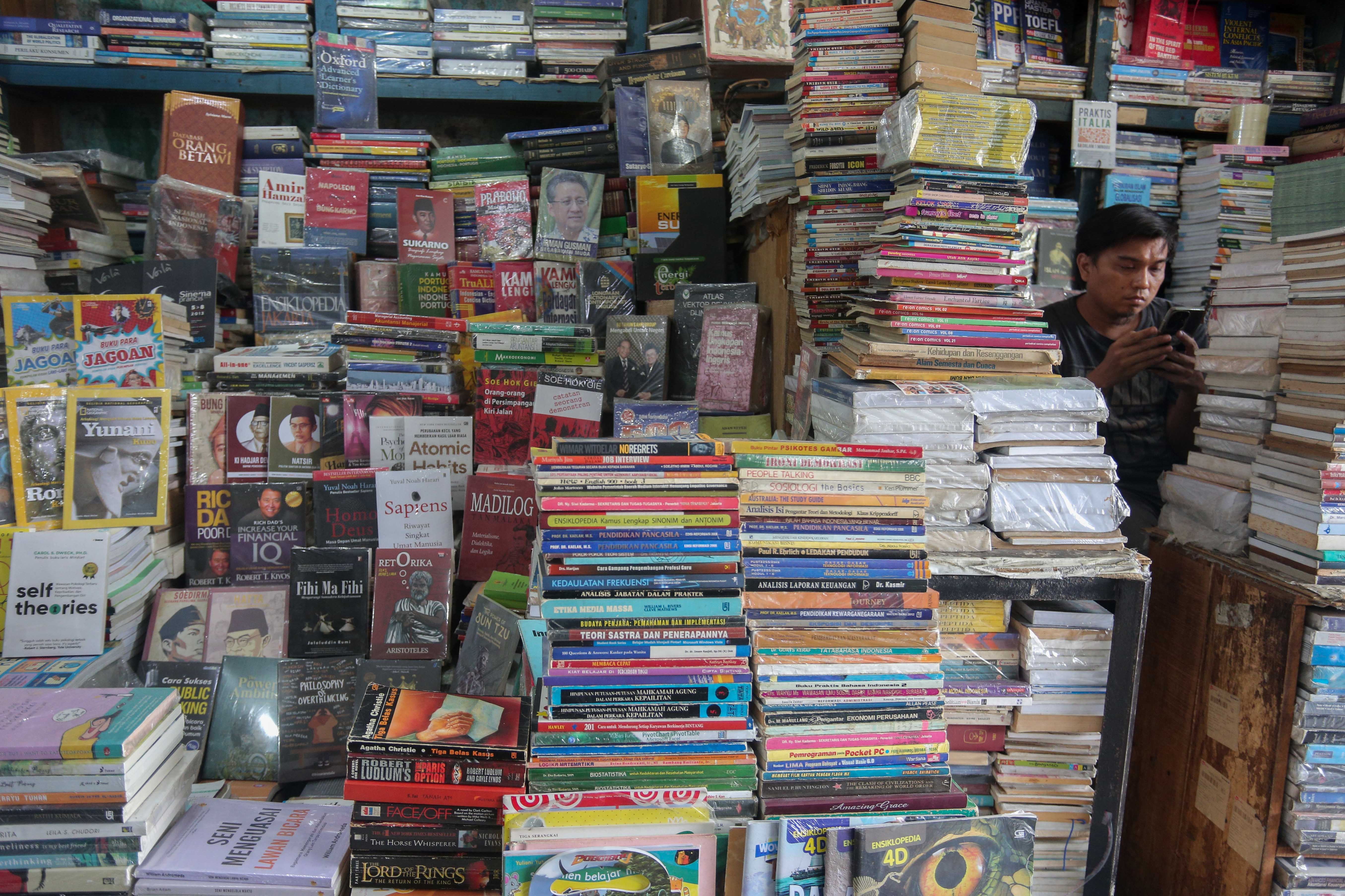 Pedagang menunggu pembeli di Pasar Buku Kwitang, Jakarta Pusat, Rabu (24/7/2024). Berdasarkan penuturan pedagang, berkembangnya teknologi membuat masyarakat beralih dari membaca buku fisik ke digital sehingga penjualan buku di pasar tersebut mengalami penurunan yang cukup signifikan.