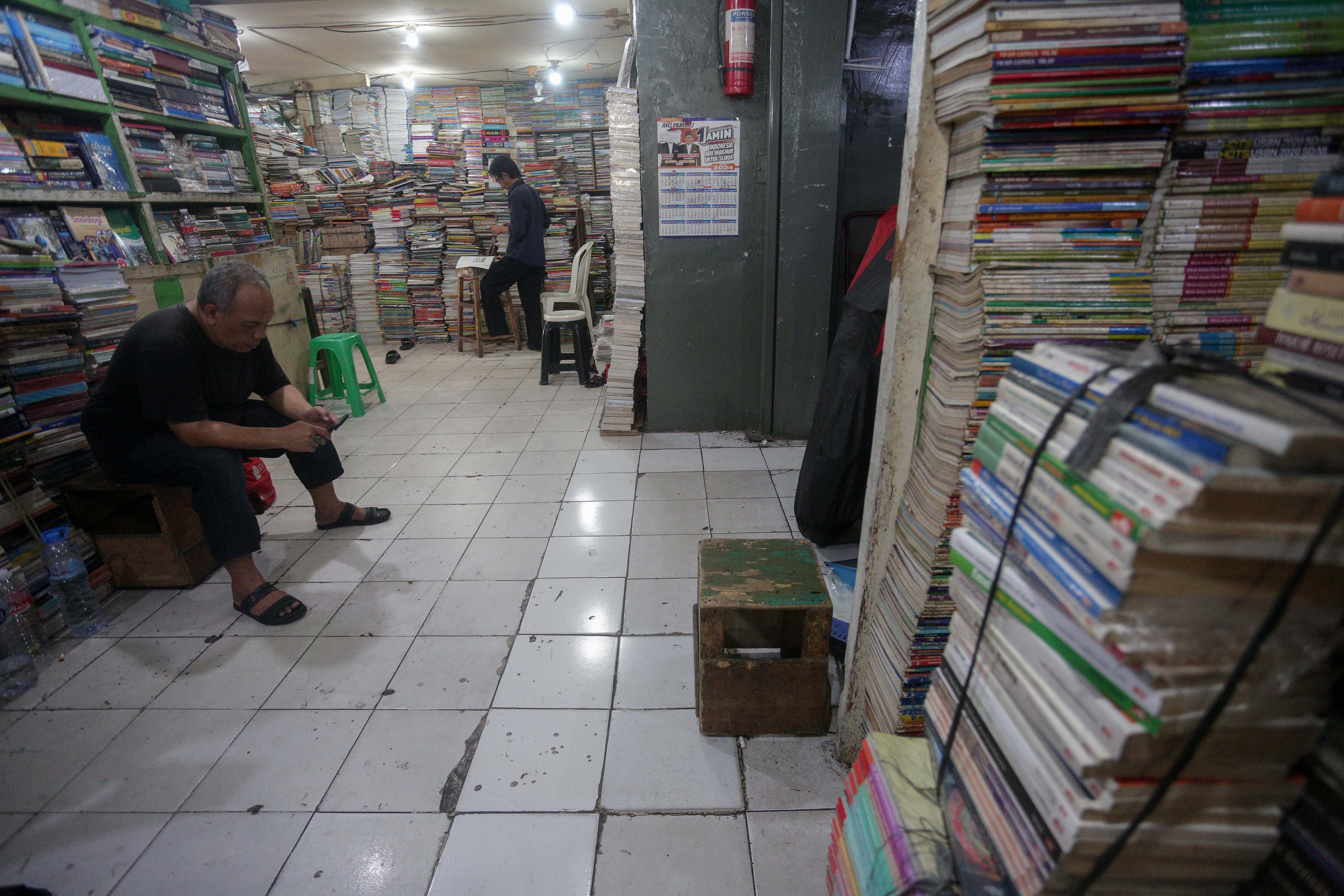 Pedagang menunggu pembeli di Pasar Buku Kwitang, Jakarta Pusat, Rabu (24/7/2024). Berdasarkan penuturan pedagang, berkembangnya teknologi membuat masyarakat beralih dari membaca buku fisik ke digital sehingga penjualan buku di pasar tersebut mengalami penurunan yang cukup signifikan.