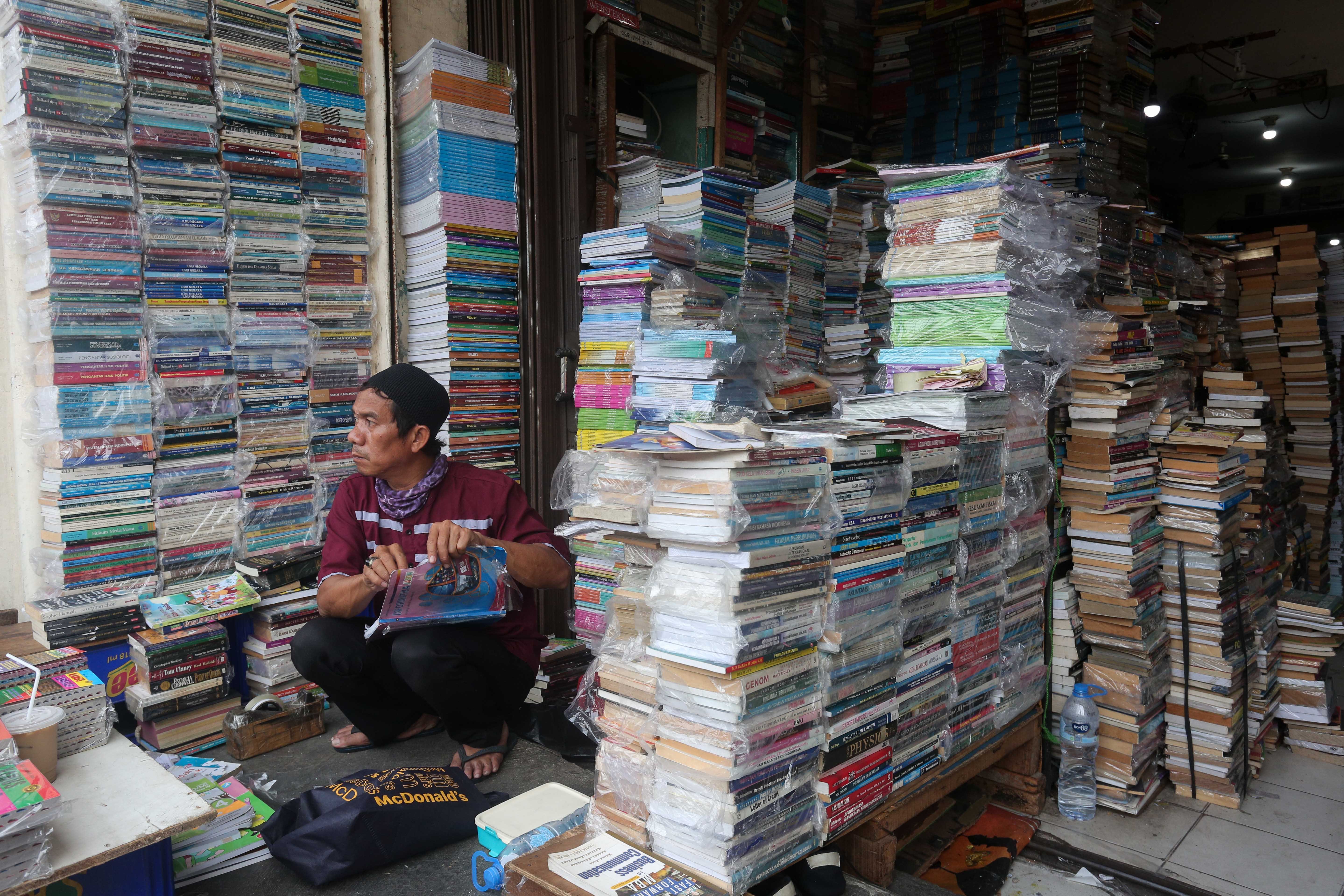 Pedagang merapikan buku yang dijual di Pasar Buku Kwitang, Jakarta Pusat, Rabu (24/7/2024). Berdasarkan penuturan pedagang, berkembangnya teknologi membuat masyarakat beralih dari membaca buku fisik ke digital sehingga penjualan buku di pasar tersebut mengalami penurunan yang cukup signifikan.