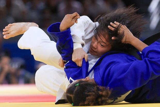 Pejudo Indonesia Maryam March Maharani (atas) membanting pejudo Mozambik Jacira Ferreira pada babak kualifikasi nomer 52 kg di Champ de Mars Arena, Paris, Prancis, Minggu (28/7/2024).