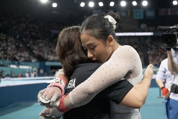 Pesenam putri Indonesia Rifda Irfanaluthfi (kanan) memeluk pelatih Eva Novalina usai bertanding pada nomor palang bertingkat kualifikasi senam artistik putri subdivision 1 Olimpiade Paris 2024 di Bercy Arena, Paris, Prancis, Minggu (28/7/2024).