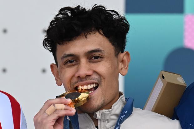 Atlet panjat tebing putra Indonesia Veddriq Leonardo menggigit medali emas usai menjuarai nomor speed putra Olimpiade Paris 2024 di Le Bourget Climbing Venue, Paris, Prancis, Kamis (8/8/2024). Veddriq Leonardo berhasil meraih medali emas dengan catatan waktu 4,75 detik mengalahkan atlet China Wu Peng yang mencatatkan waktu 4,77 detik.