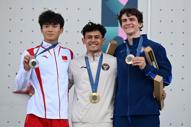 Atlet panjat tebing putra Indonesia peraih medali emas Veddriq Leonardo (tengah) berfoto bersama atlet China peraih medali perak Wu Peng (kiri) dan atlet Amerika Serikat peraih medali perunggu Sam Watson seusai penyerahan medali final nomor speed putra Olimpiade Paris 2024 di Le Bourget Climbing Venue, Paris, Prancis, Kamis (8/8/2024). Veddriq Leonardo meraih medali emas dengan catatan waktu 4,75 detik.