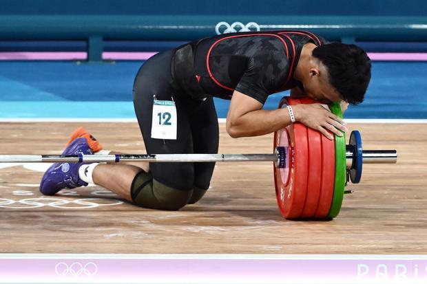 Lifter Indonesia Rizki Juniansyah mencium barbel usai melakukan angkatan clean and jerk dalam kelas 73 kg putra Olimpiade Paris 2024 di South Paris Arena, Paris, Prancis, Kamis (8/8/2024). Rizki meraih medali emas setelah berhasil meraih total angkatan 354 kilogram sehingga menduduki peringkat pertama dari 12 lifter yang turut serta dalam nomor tersebut.