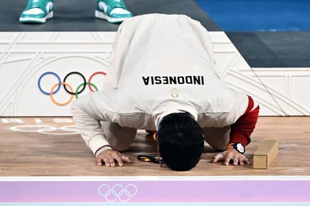 Lifter Indonesia Rizki Juniansyah bersujud syukur usai upacara pengalungan medali kelas 73 kg putra Olimpiade Paris 2024 di South Paris Arena, Paris, Prancis, Kamis (8/8/2024). Rizki meraih medali emas setelah berhasil meraih total angkatan 354 kilogram sehingga menduduki peringkat pertama dari 12 lifter yang turut serta dalam nomor tersebut.