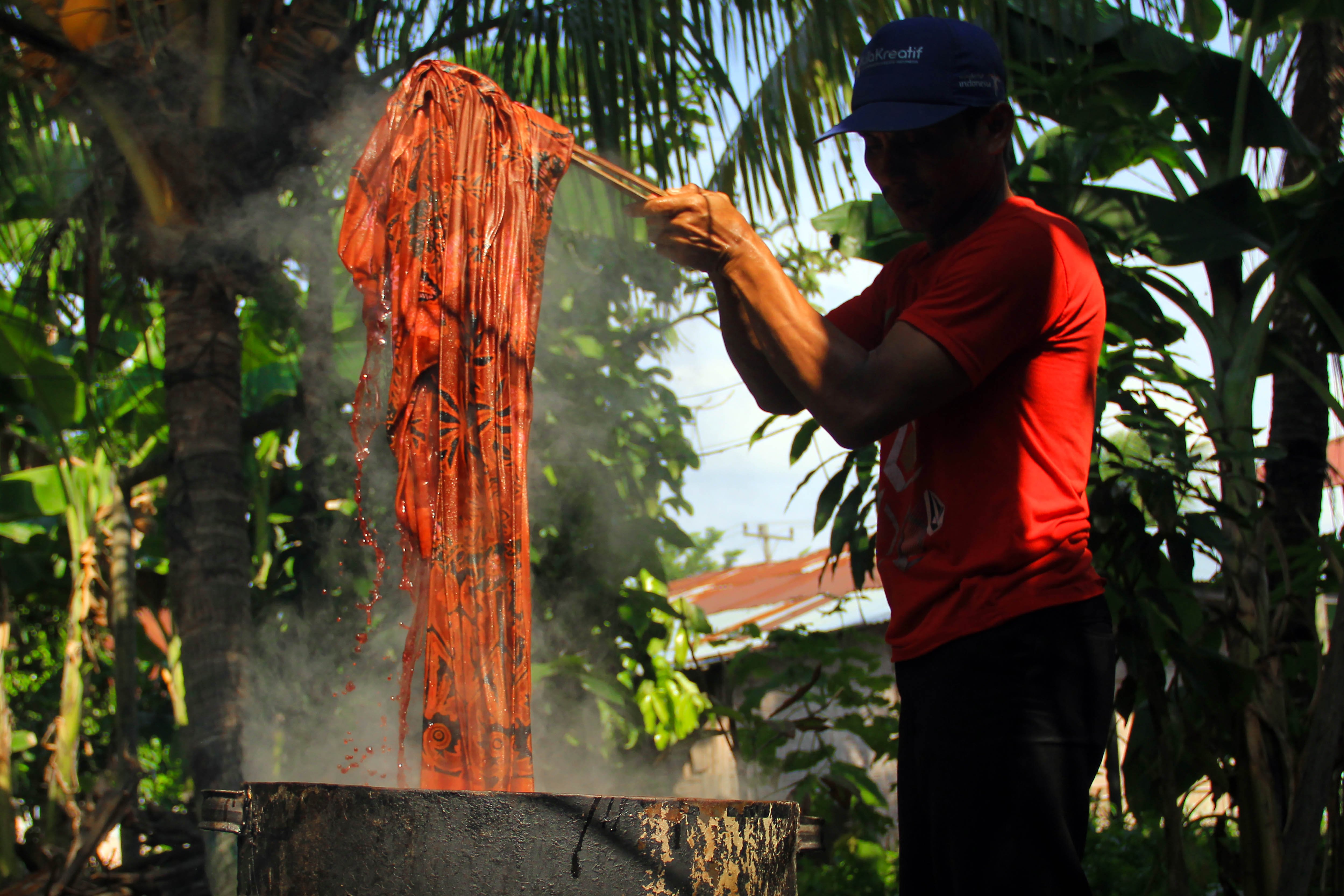 Perajin merebus kain batik untuk melunturkan lilin di Desa Pematang Johar, Kabupaten Deli Serdang, Sumatra Utara.