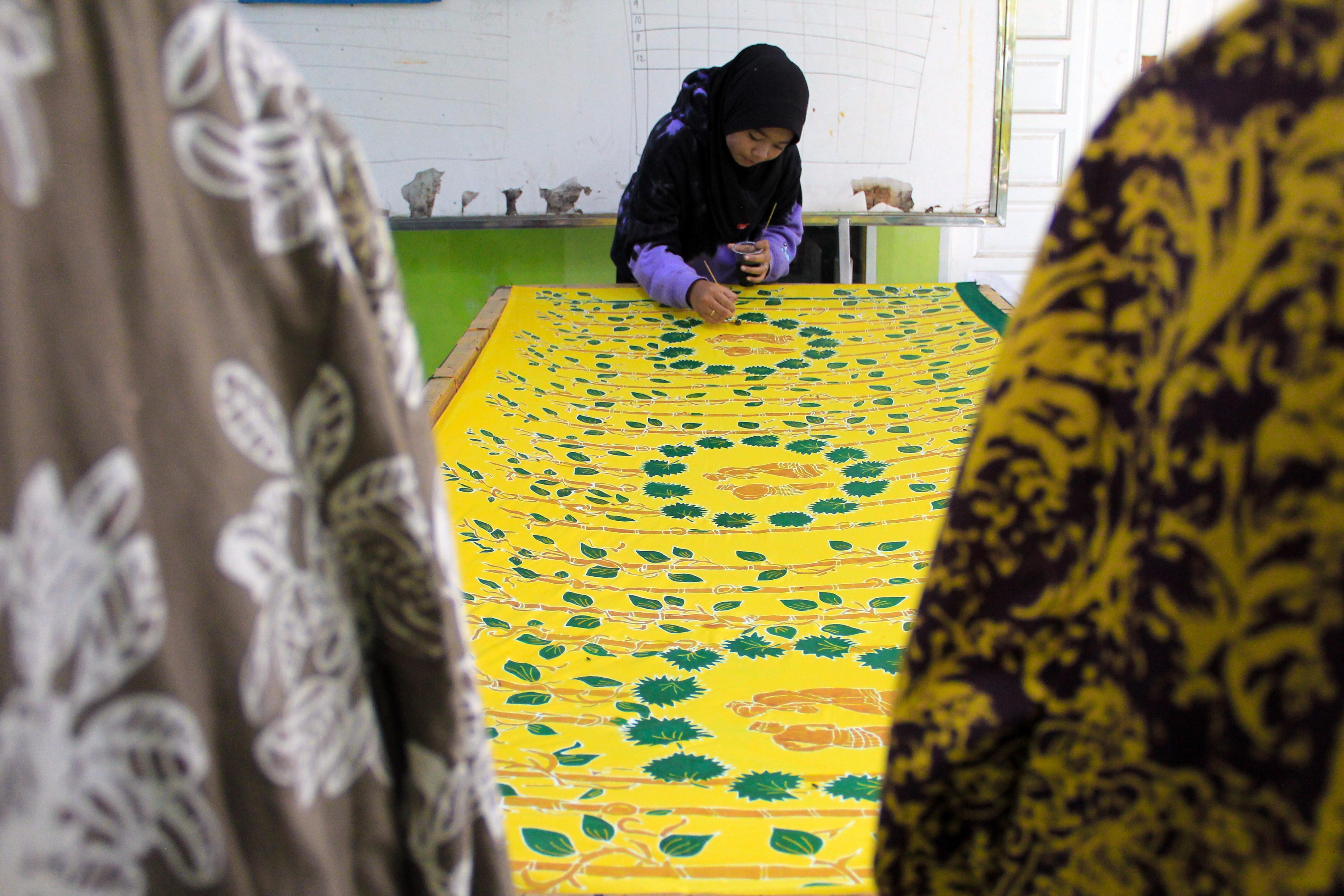 Perajin membuat motif batik dengan pewarna mangrove di Desa Pematang Johar, Deli Serdang.