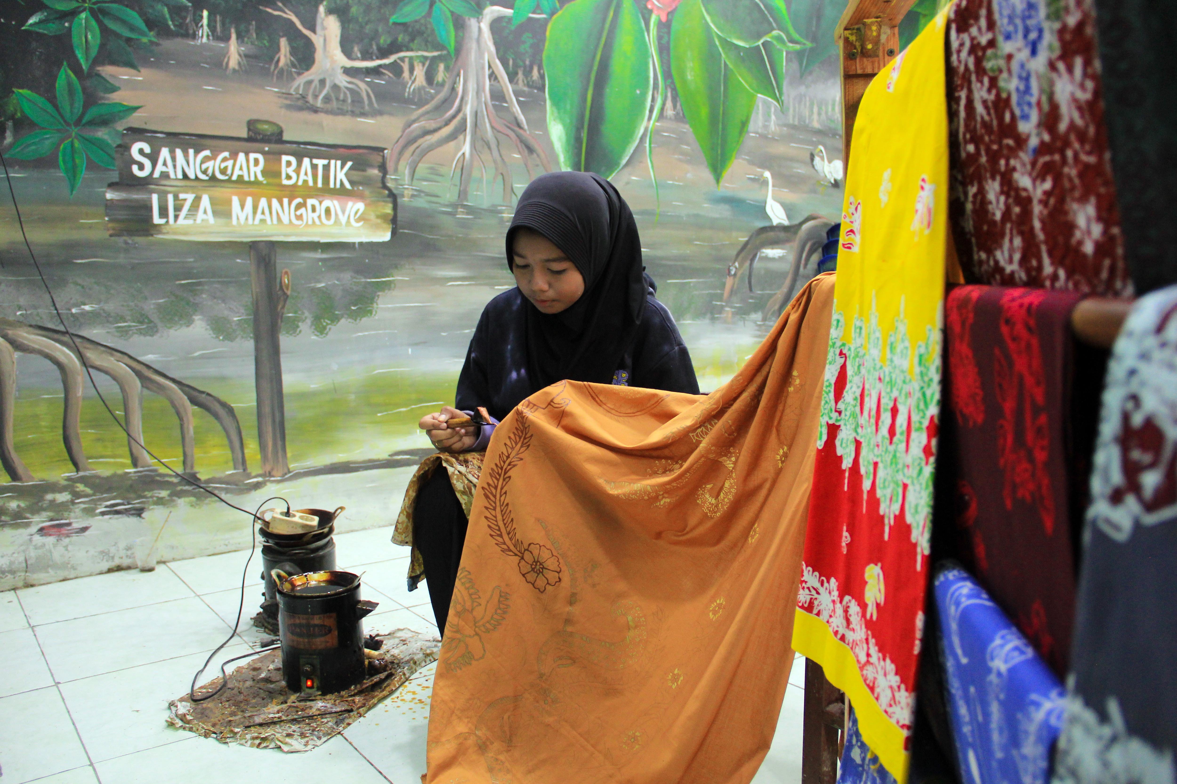 Perajin melukis batik menggunakan pewarna dari mangrove di Desa Pematang Johar, Deli Serdang.