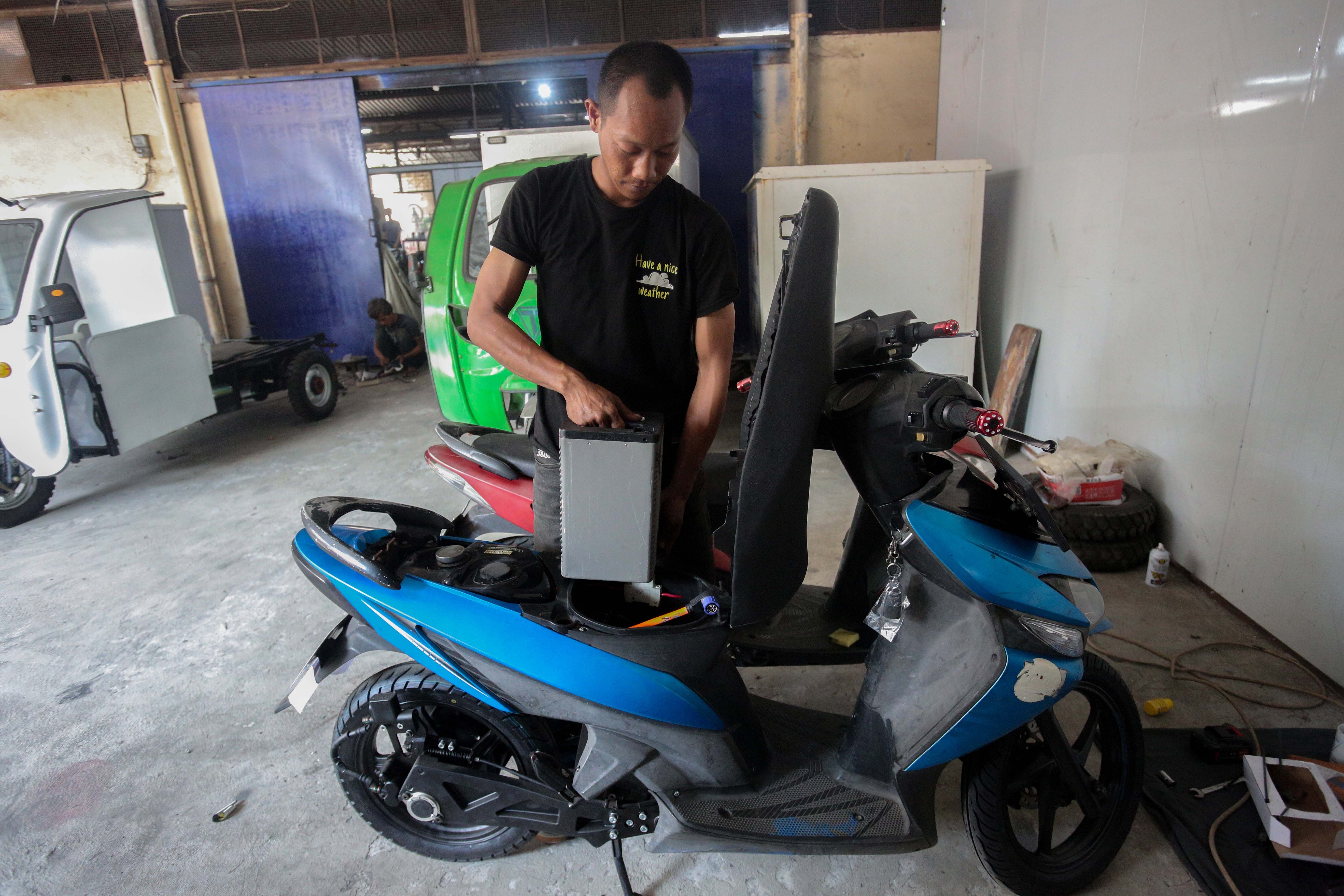 Teknisi memasang baterai pada motor listrik yang telah selesai dikonversi di bengkel PT. Tomara Jaya Perkasa, Jakarta Timur, Selasa (13/8/2024). Kementerian Energi dan Sumber Daya Mineral (ESDM) mengadakan program konversi motor listrik gratis bagi warga Jabodetabek dengan biaya konversi sebesar Rp16 juta per unit dan kuota sebanyak 500 sepeda motor.