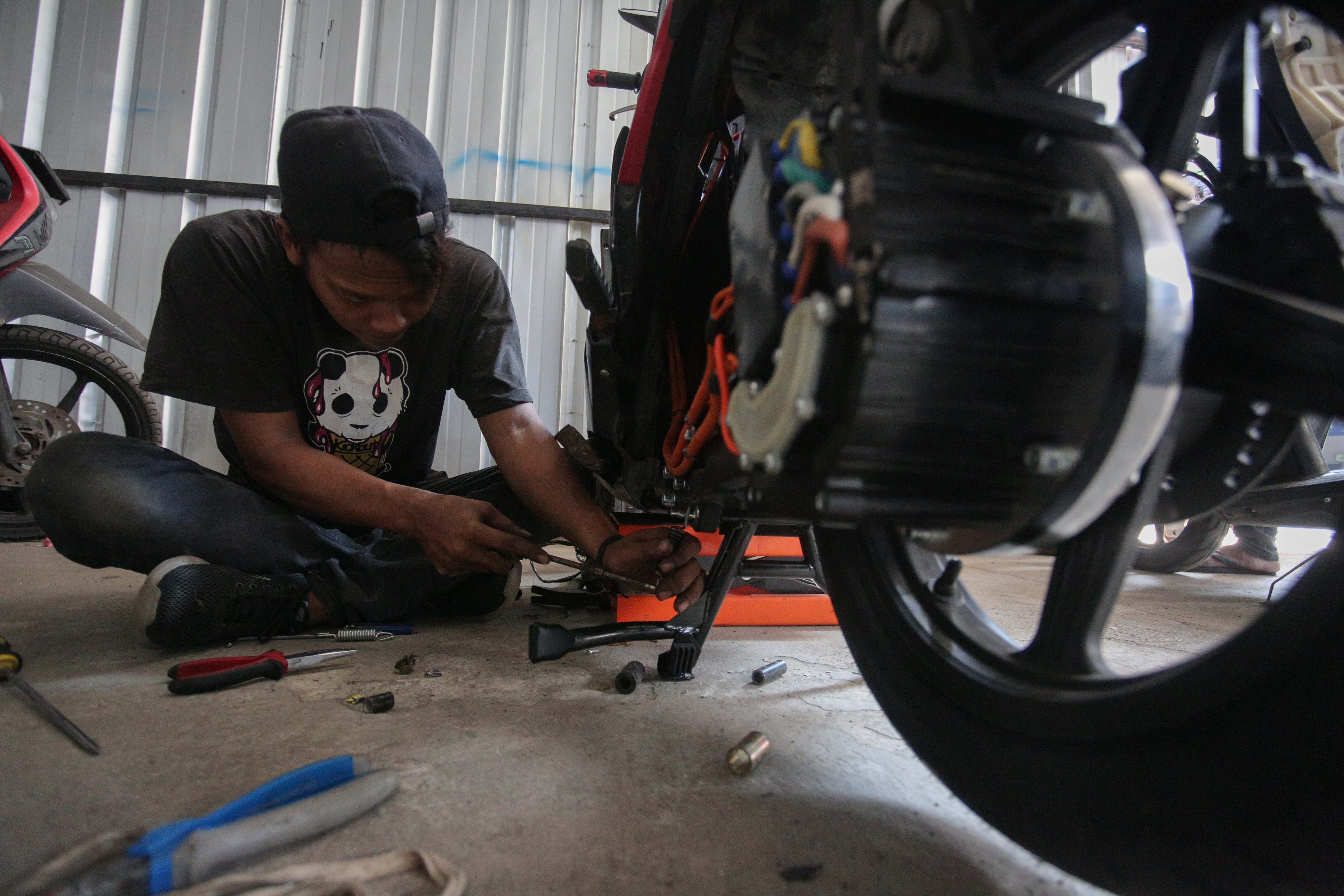 Teknisi menyelesaikan proses konversi motor berbahan bakar minyak menjadi motor listrik di bengkel PT. Tomara Jaya Perkasa, Jakarta Timur, Selasa (13/8/2024). Kementerian Energi dan Sumber Daya Mineral (ESDM) mengadakan program konversi motor listrik gratis bagi warga Jabodetabek dengan biaya konversi sebesar Rp16 juta per unit dan kuota sebanyak 500 sepeda motor.