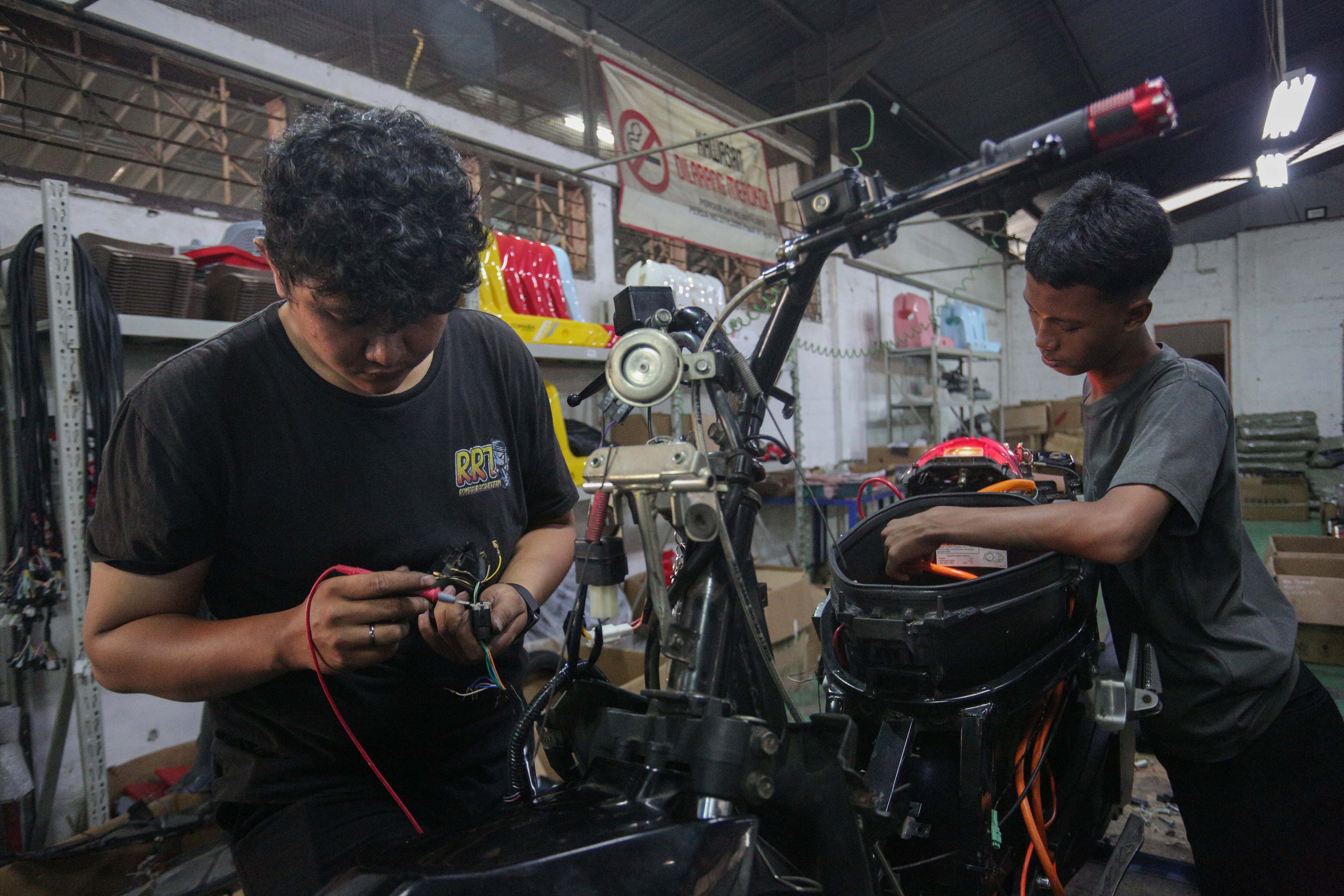 Teknisi menyelesaikan proses konversi motor berbahan bakar minyak menjadi motor listrik di bengkel PT. Tomara Jaya Perkasa, Jakarta Timur, Selasa (13/8/2024). Kementerian Energi dan Sumber Daya Mineral (ESDM) mengadakan program konversi motor listrik gratis bagi warga Jabodetabek dengan biaya konversi sebesar Rp16 juta per unit dan kuota sebanyak 500 sepeda motor.