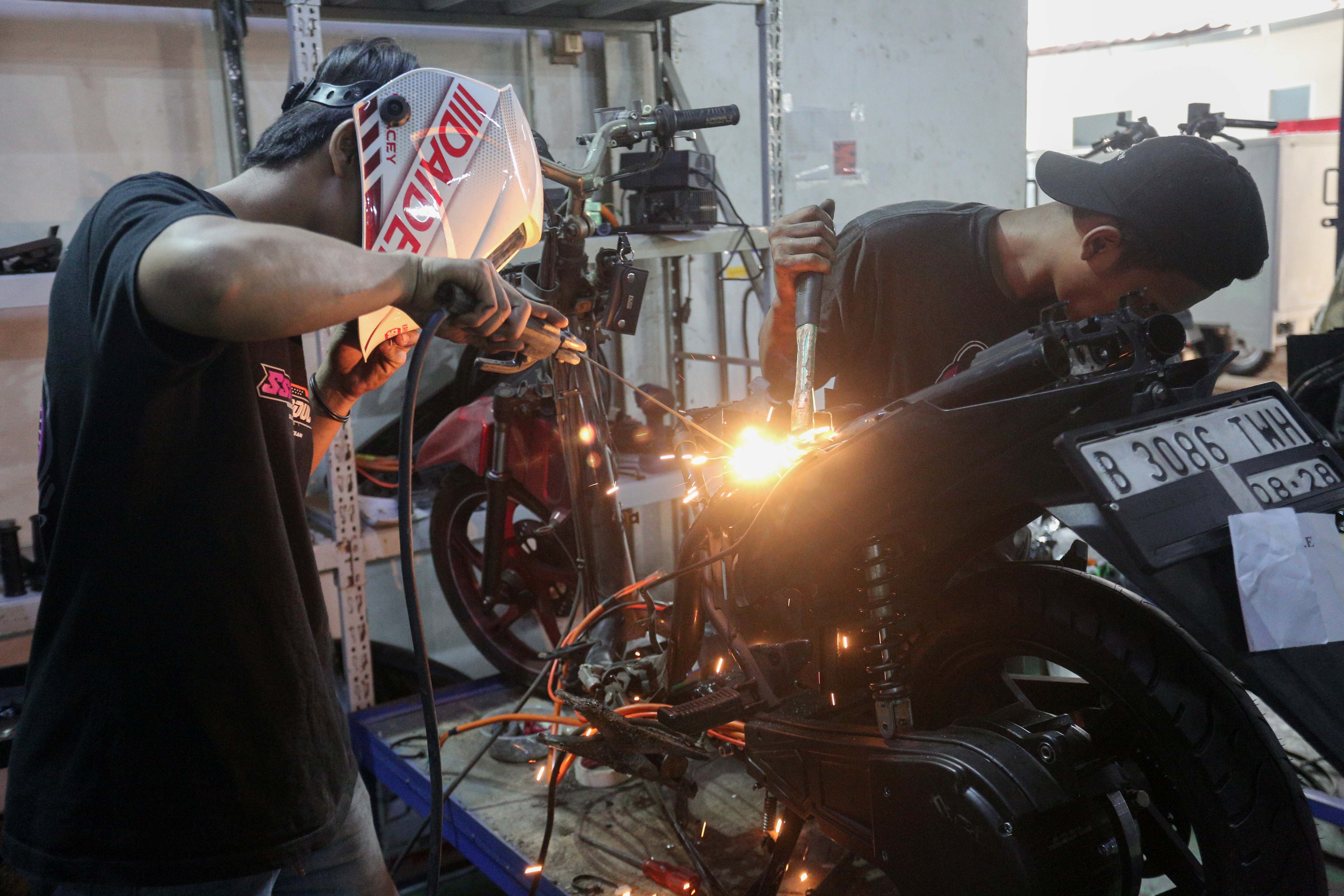Teknisi menyelesaikan proses konversi motor berbahan bakar minyak menjadi motor listrik di bengkel PT. Tomara Jaya Perkasa, Jakarta Timur, Selasa (13/8/2024). Kementerian Energi dan Sumber Daya Mineral (ESDM) mengadakan program konversi motor listrik gratis bagi warga Jabodetabek dengan biaya konversi sebesar Rp16 juta per unit dan kuota sebanyak 500 sepeda motor.