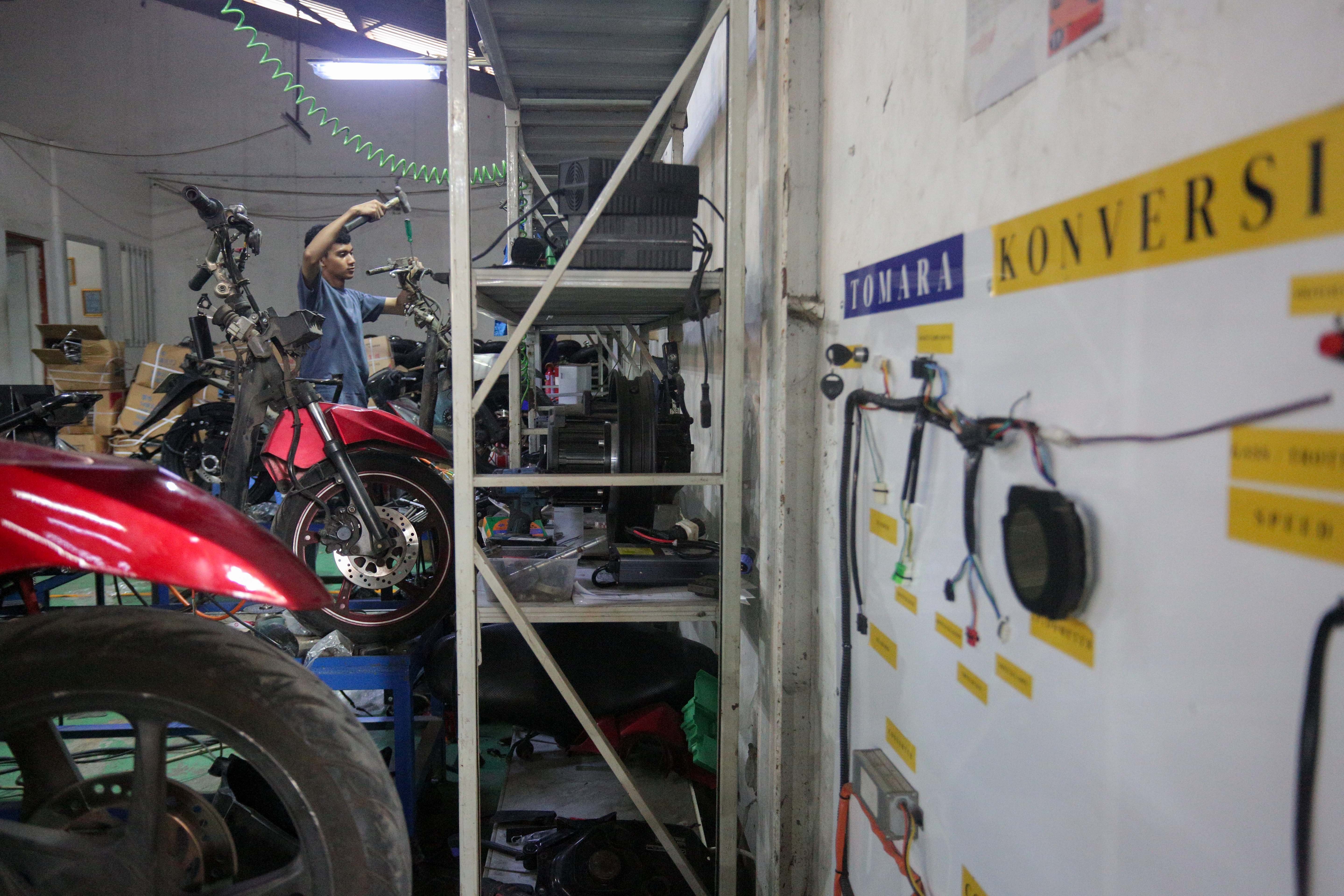 Teknisi menyelesaikan proses konversi motor berbahan bakar minyak menjadi motor listrik di bengkel PT. Tomara Jaya Perkasa, Jakarta Timur, Selasa (13/8/2024). Kementerian Energi dan Sumber Daya Mineral (ESDM) mengadakan program konversi motor listrik gratis bagi warga Jabodetabek dengan biaya konversi sebesar Rp16 juta per unit dan kuota sebanyak 500 sepeda motor.