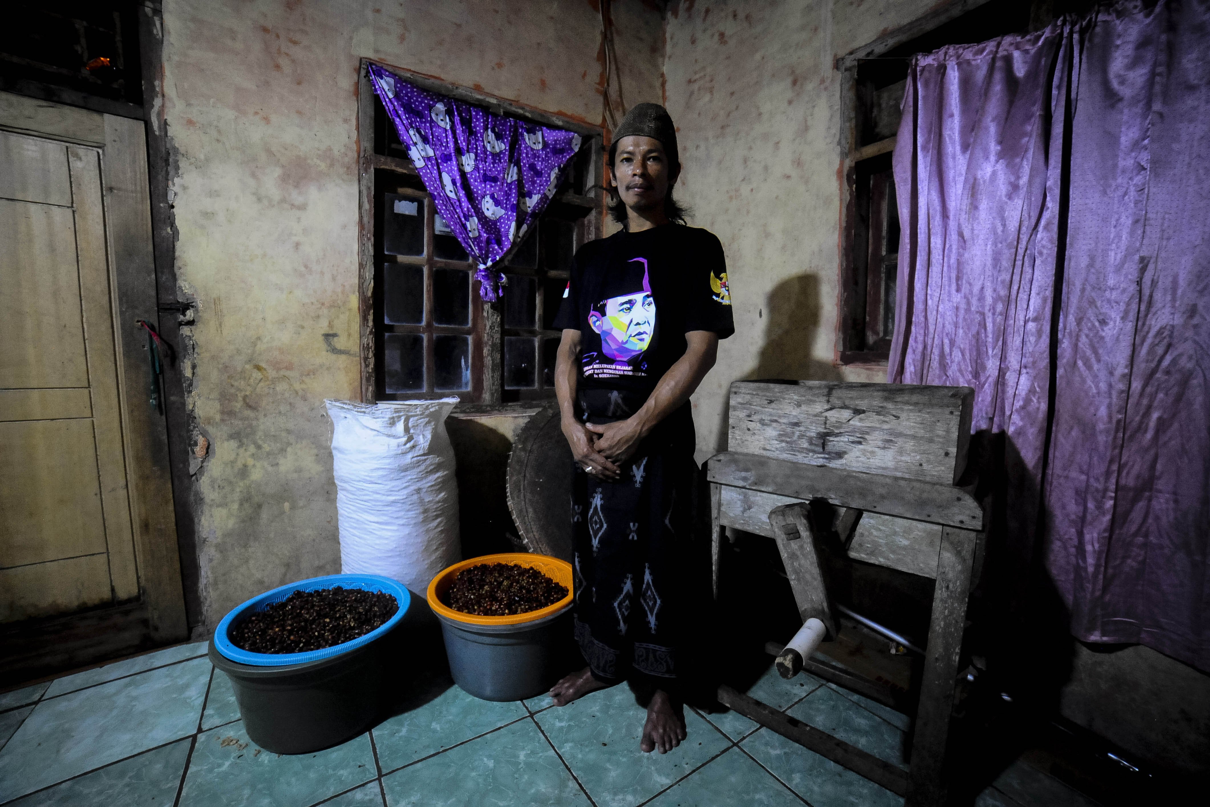 Apandi berpose di tempat penggilingan kopi robusta (Coffea Canephora) di rumahnya, Kampung Ciodeng, Pandeglang, Banten.