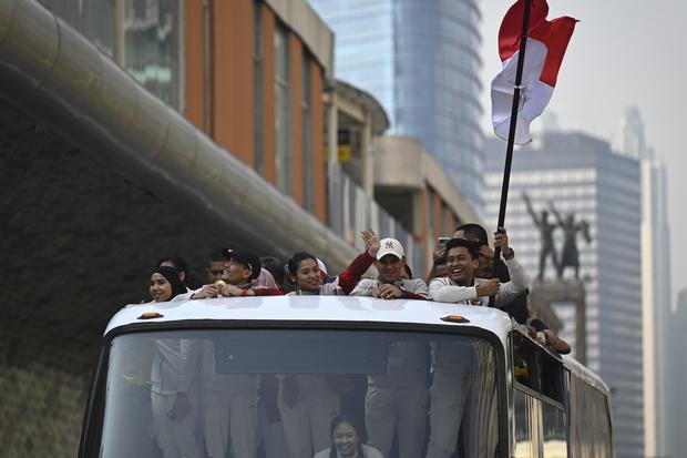 Sejumlah atlet dan ofisial mengikuti arak-arakan dengan menaiki bus tingkat terbuka dari Kantor Kemenpora menuju Istana Negara ketika melintas di Kawasan Bundaran HI, Jakarta, Kamis (15/8/2024). Arak-arakan yang diikuti atlet dan ofisial itu untuk menyambut atlet yang telah mempersembahkan dua medali emas melalui Rizki Juniansyah dari cabang olahraga angkat besi dan pemanjat tebing Veddriq Leonardo, serta satu perunggu melalui pebulu tangkis Gregoria Mariska Tunjung pada OIimpiade Paris 2024.