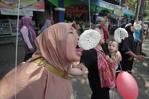 Pedagang mengikuti lomba makan krupuk di kawasan Pasar Larangan, Sidoarjo, Kamis (15/8/2024). Perlombaan yang diikuti para pedagang pasar tradisional tersebut digelar untuk memeriahkan HUT ke-79 Kemerdekaan Republik Indonesia sekaligus meningkatkan kerukunan dan kekompakan antarwarga.