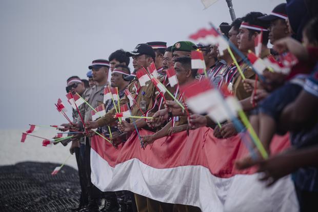 Sejumlah personil Kepolisian, TNI dan sejumlah instansi mengibarkan bendera merah putih di Pulau Pelampong, Batam, Kepulauan Riau, Kamis (15/8/2024). Pengibaran bendera merah putih di pulau kecil terluar yang berbatasan langsung dengan perairan Singapura tersebut dalam rangka menyambut dan menyemarakkan HUT ke-79 kemerdekaan RI.