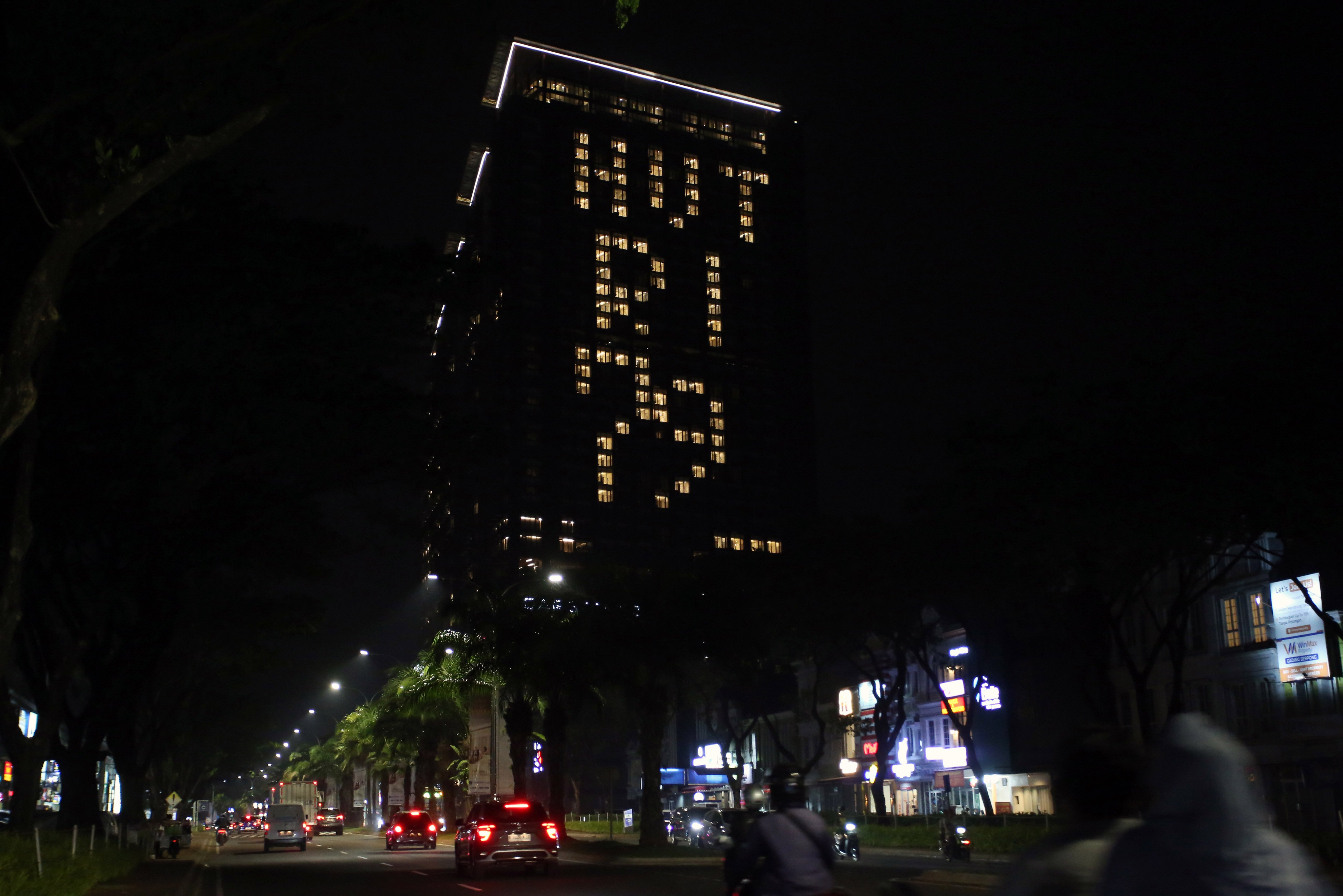 Sebuah apartemen yang juga pusat perbelanjaan menyalakan lampu kamar membentuk tulisan 